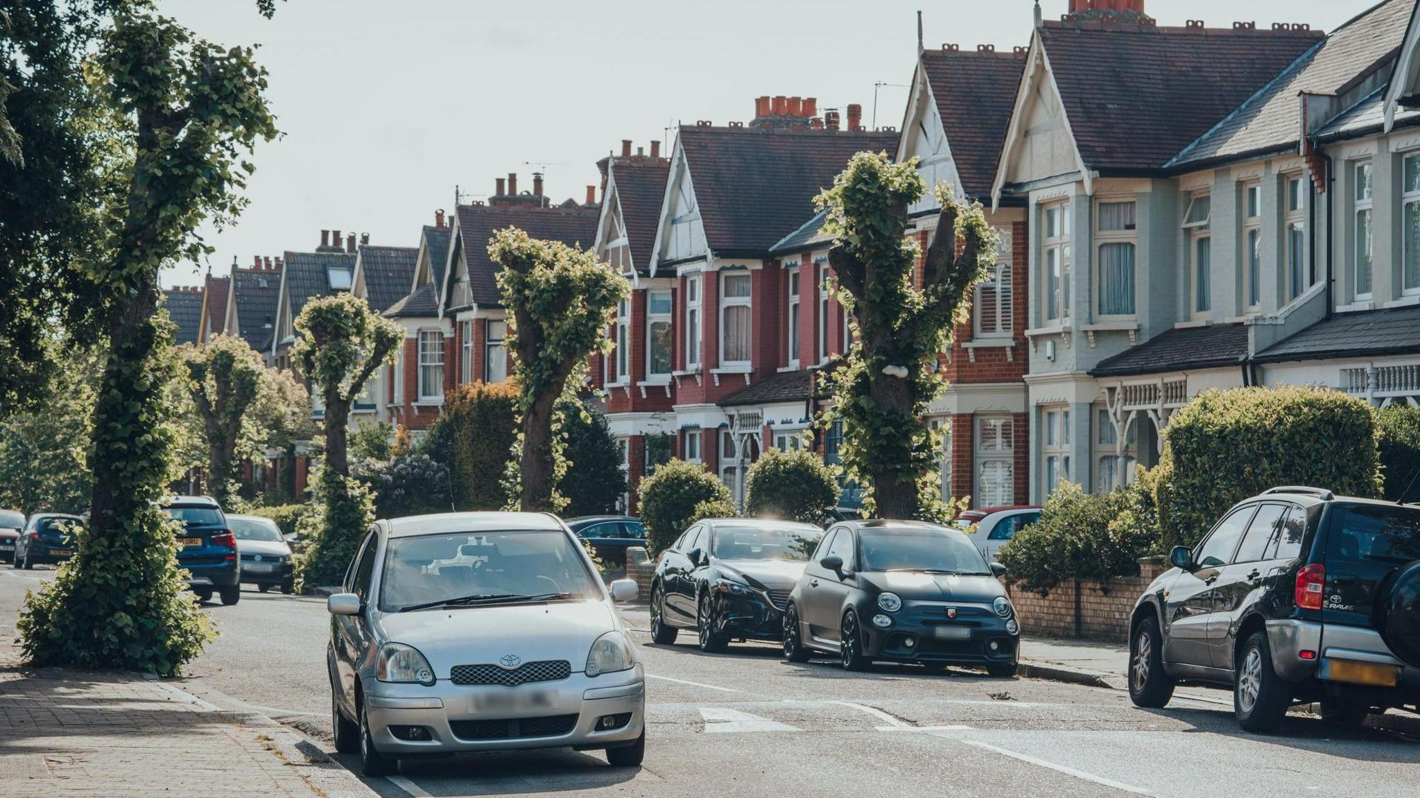 A general view of cars parked in front of houses on both sides of a street in Palmers Green, in the borough of Enfield.