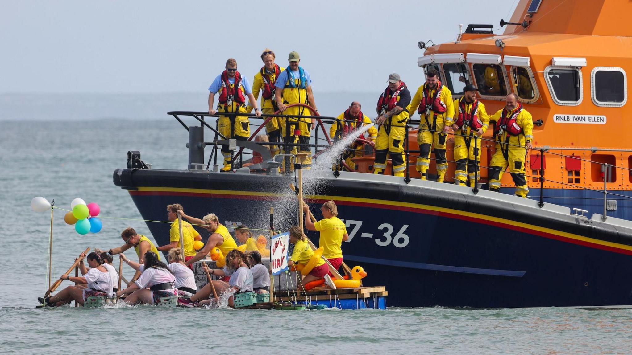 A lifeboat crew hoses two rafts which are close to their boat.
