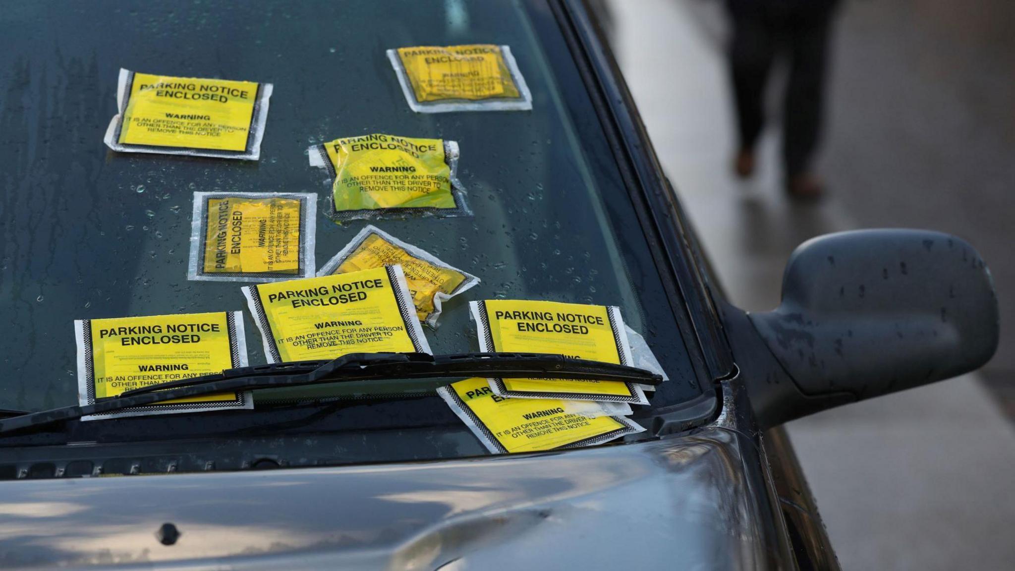 A Land Rover with several Penalty Charge Notices on its windscreen