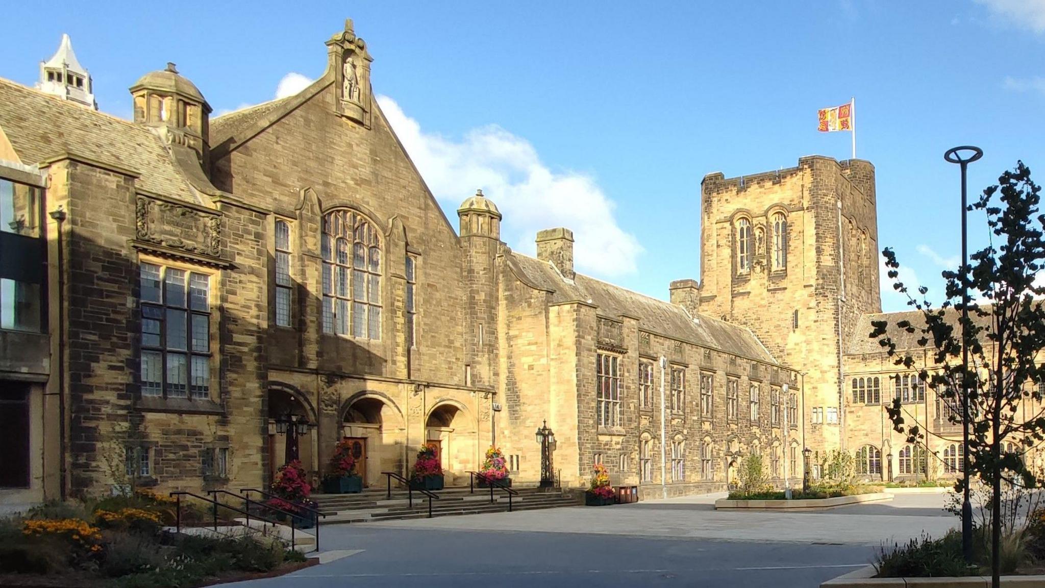Llun o gampws Prifysgol Bangor ar ddiwrnod braf