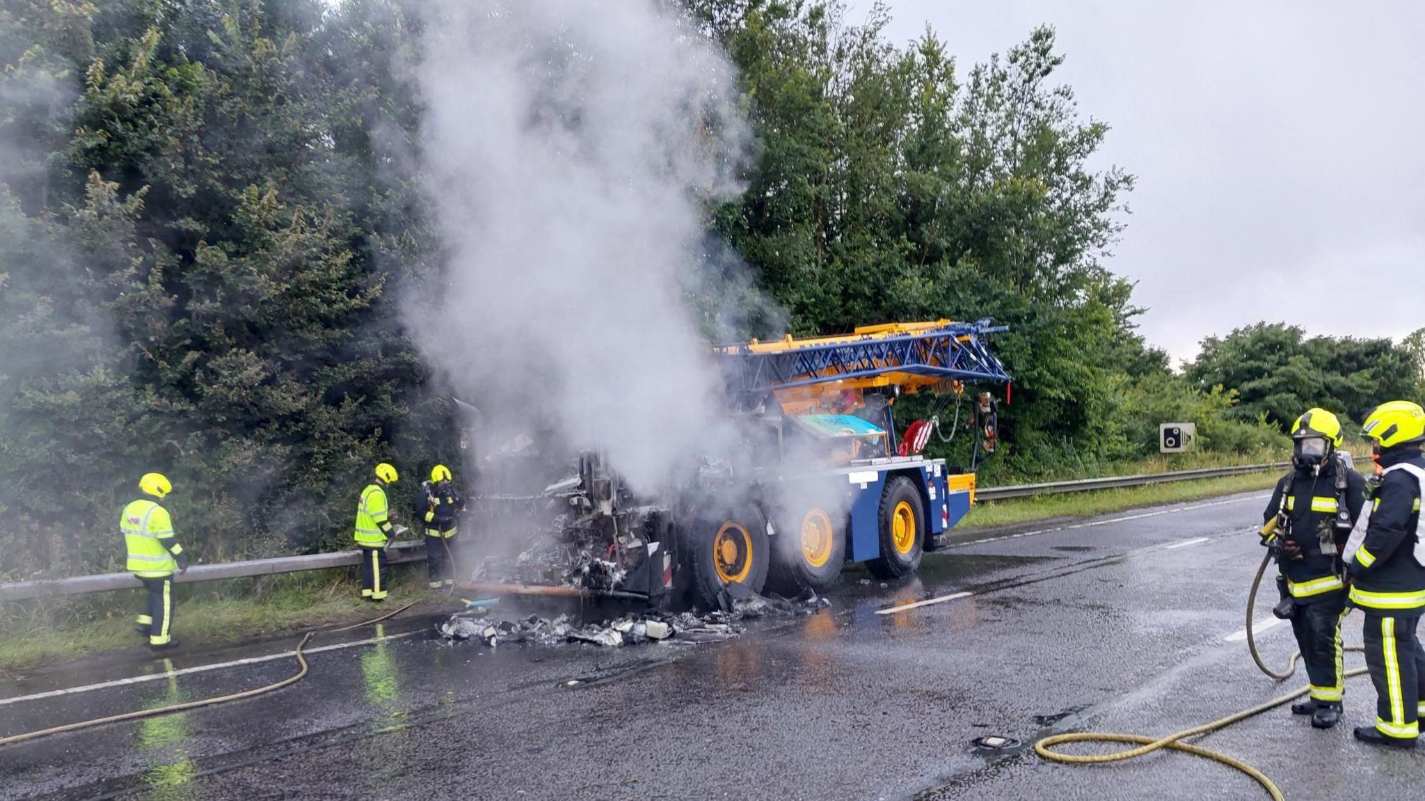 Crane which was on fire being put out by emergency services on the A38 in Plymouth