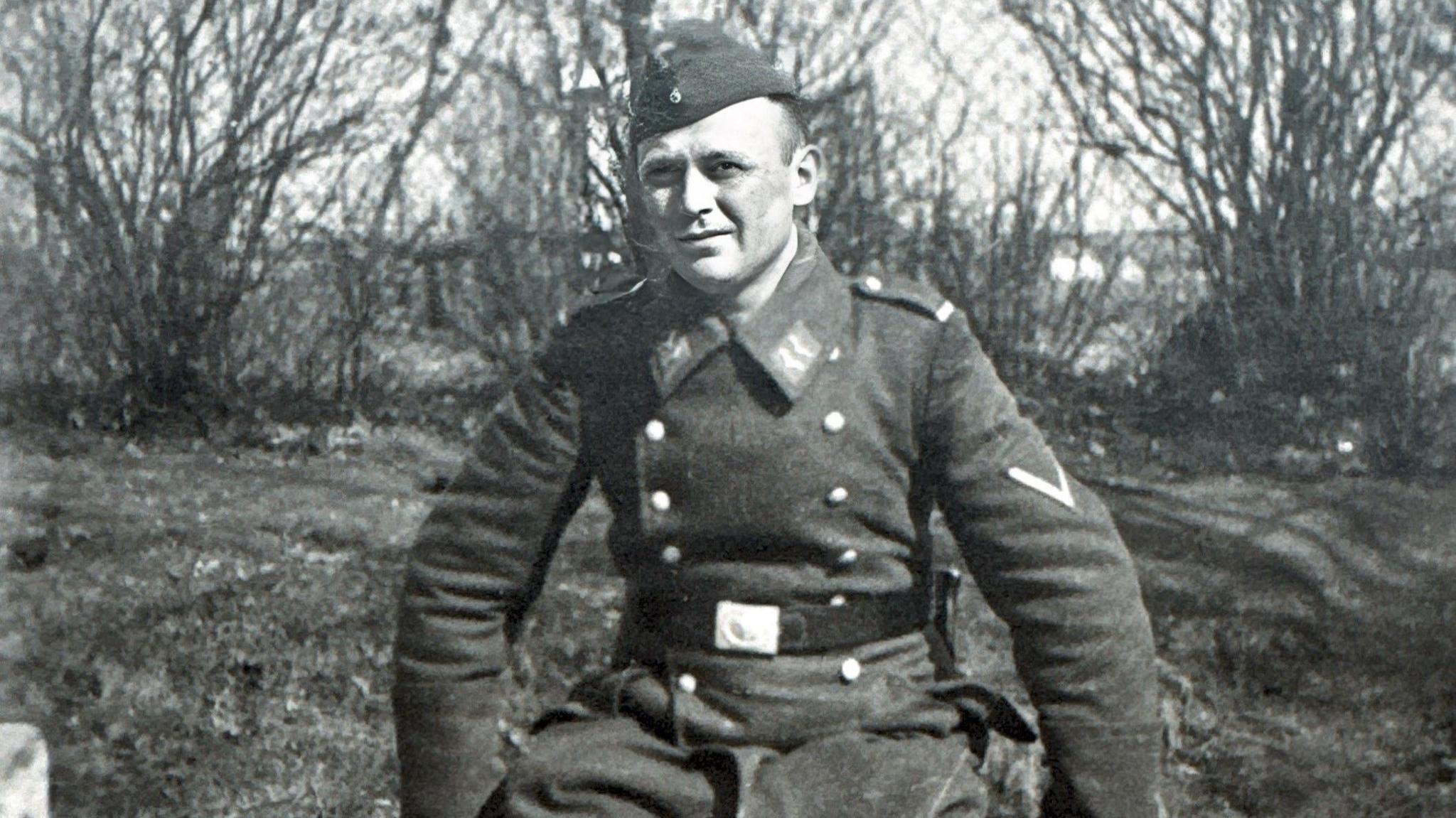 A man sitting down wearing a German Luftwaffe uniform.