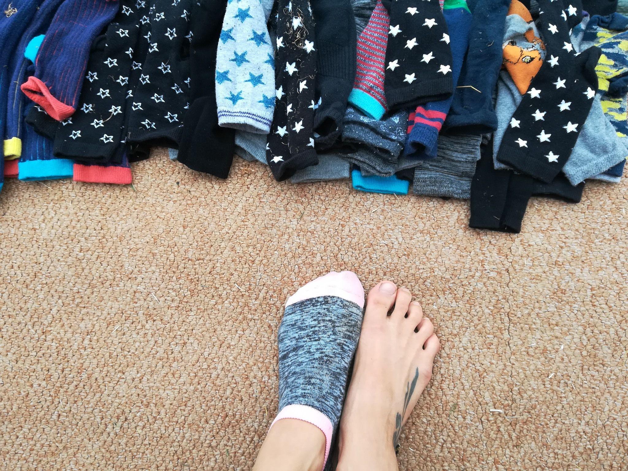 Photo shows a pile of socks, and a child's feet, as they prepare for around of sock wrestling