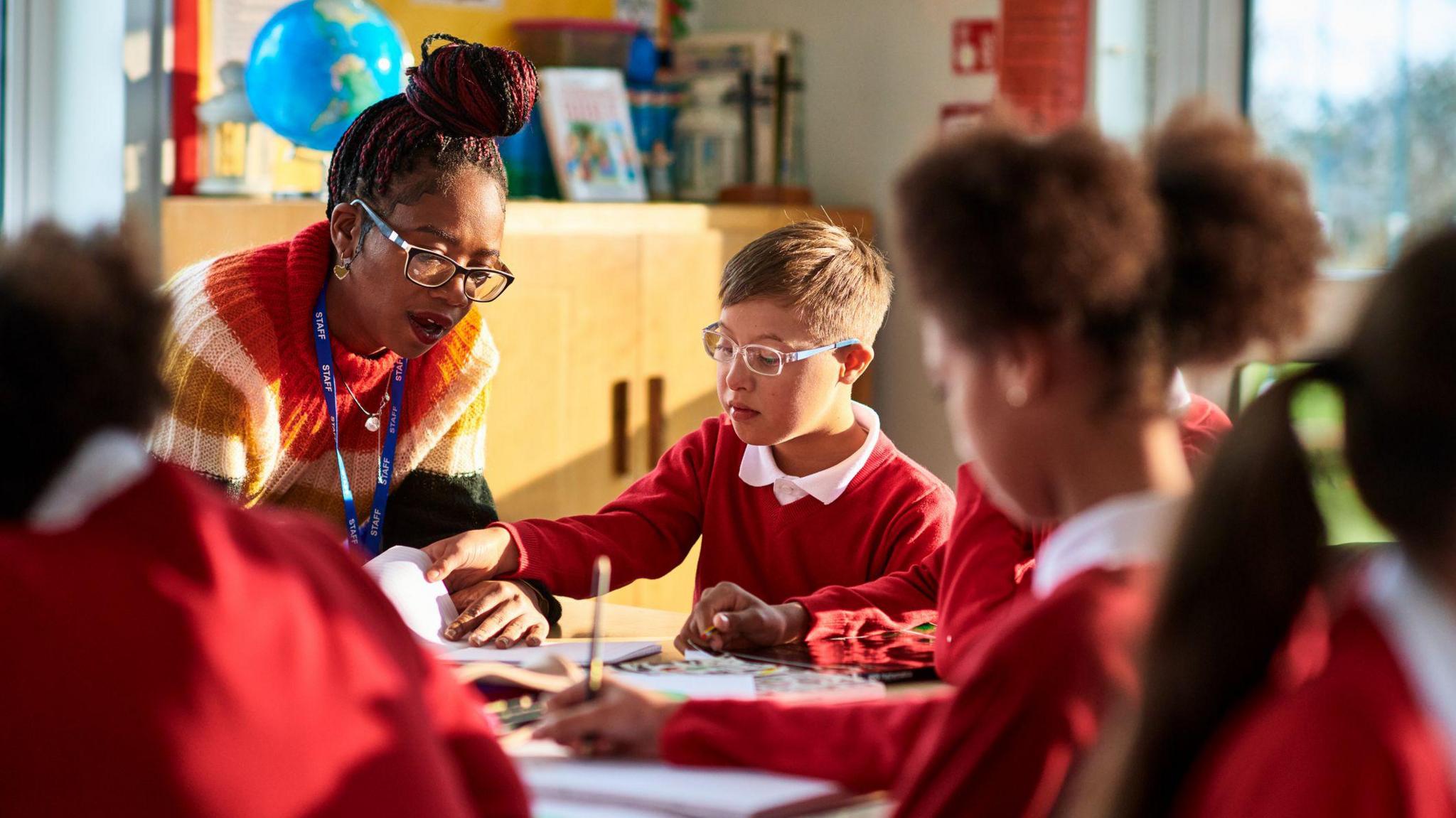 a teacher helping a child studying in school