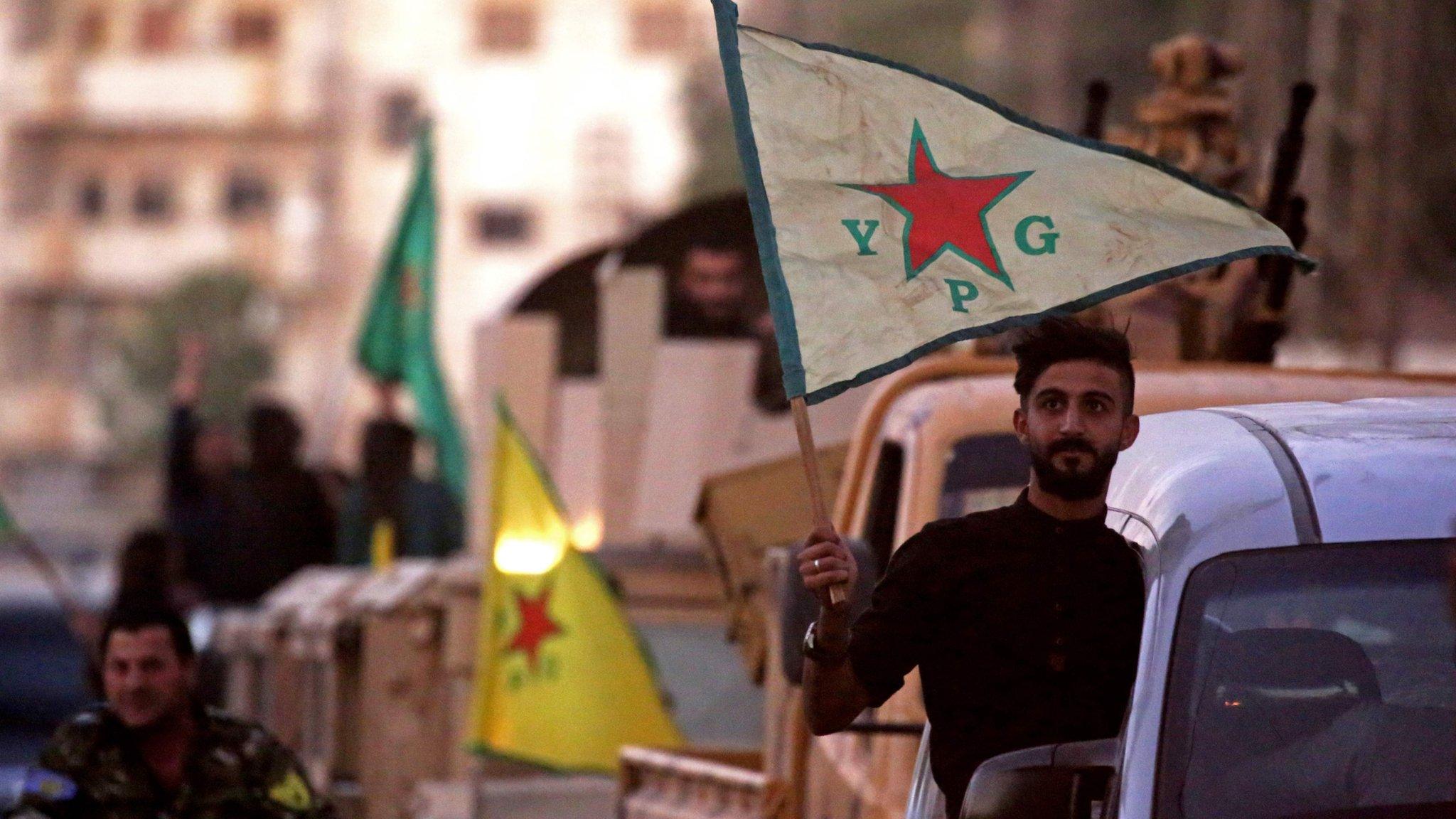 YPG fighters celebrate after Syrian Democratic Forces (SDF) announced they had taken full control of Raqqa from the Islamic State group on October 17, 2017