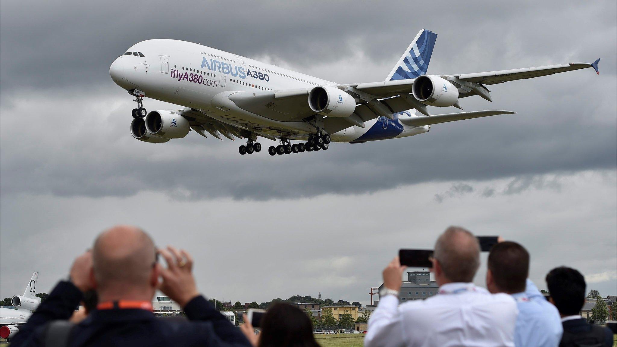 Plane enthusiasts watch an Airbus A380 during a flight demonstration at the Farnborough International Airshow,