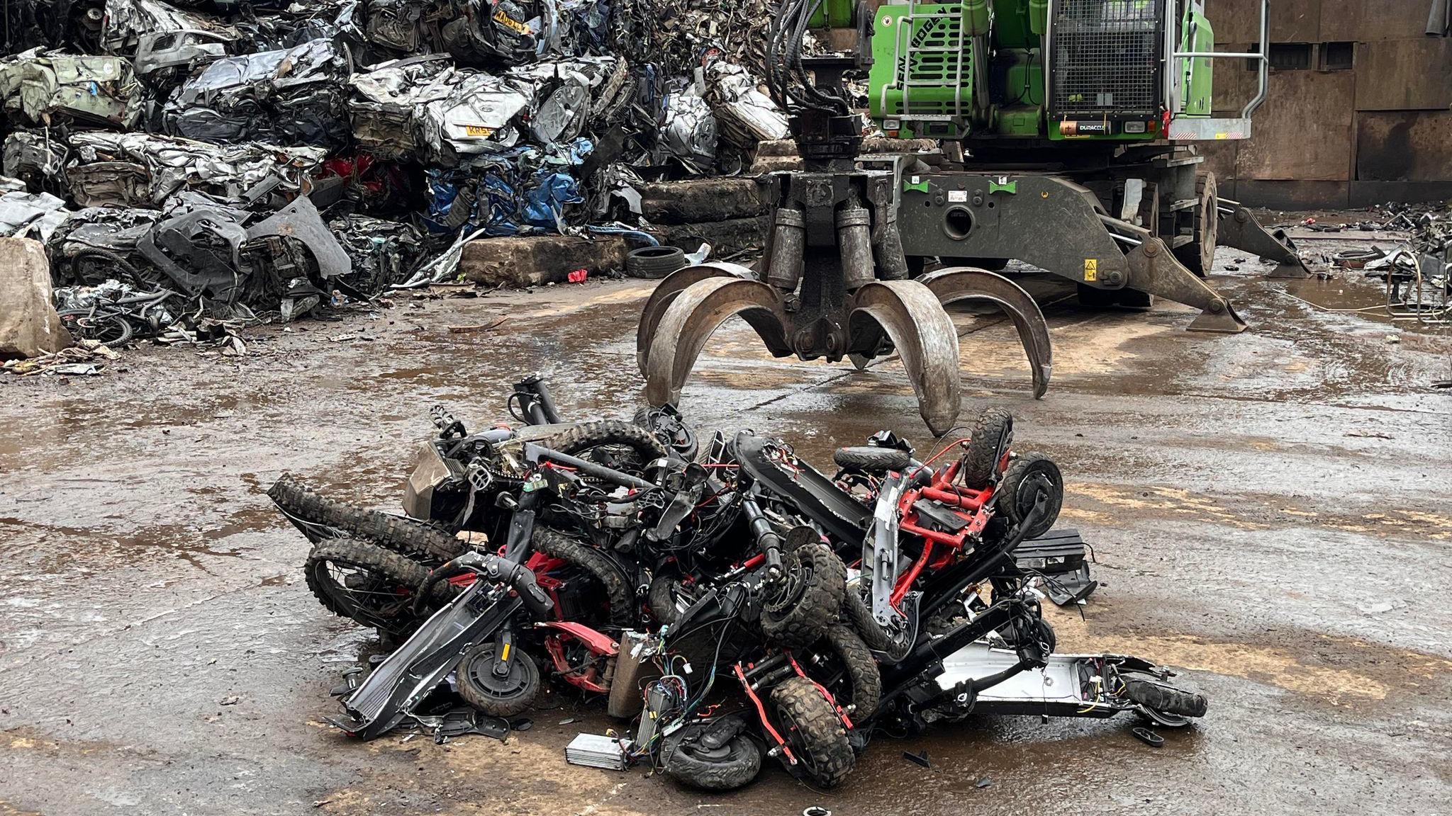 The picture shows e-scooters and motorcycles seized from people involved in anti-social behaviour or other crimes being crushed.