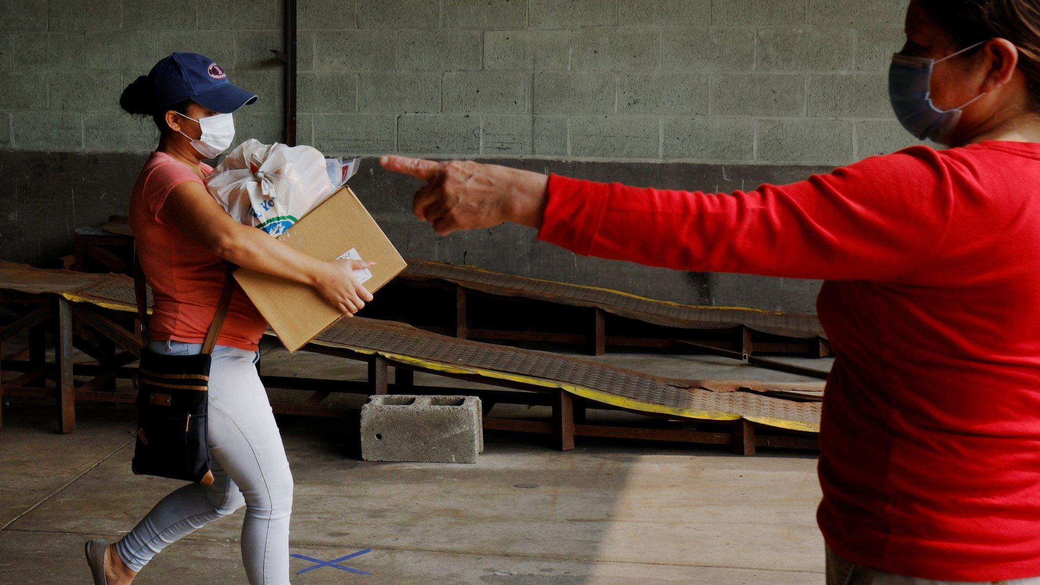 A resident picks up free groceries distributed by the Chelsea Collaborative"s food pantry, in Chelsea, a city hard hit by the coronavirus disease (COVID-19) outbreak, Massachusetts, U.S., September 15, 2020.