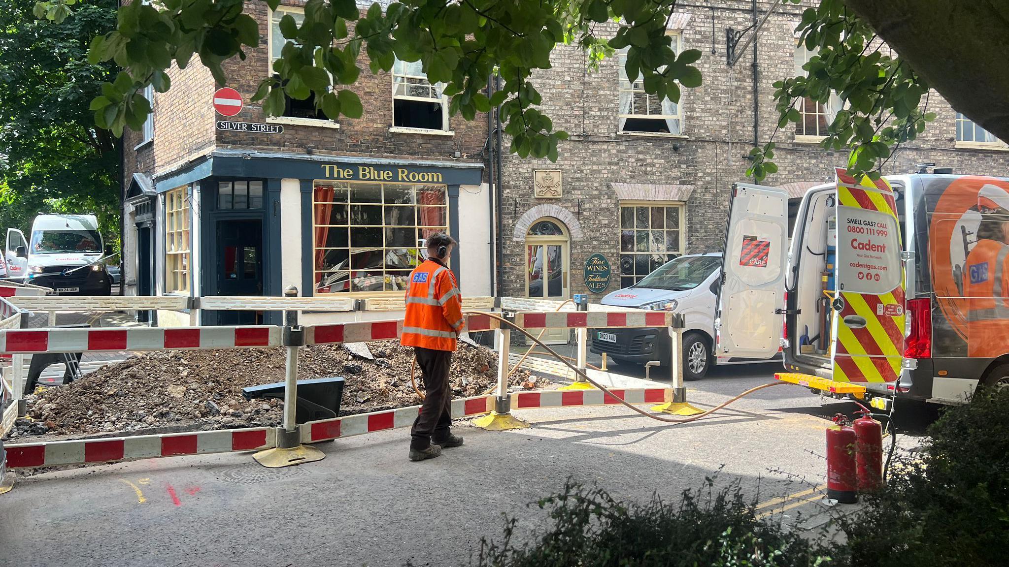 A Cadent worker standing next to a dug-up section of the road