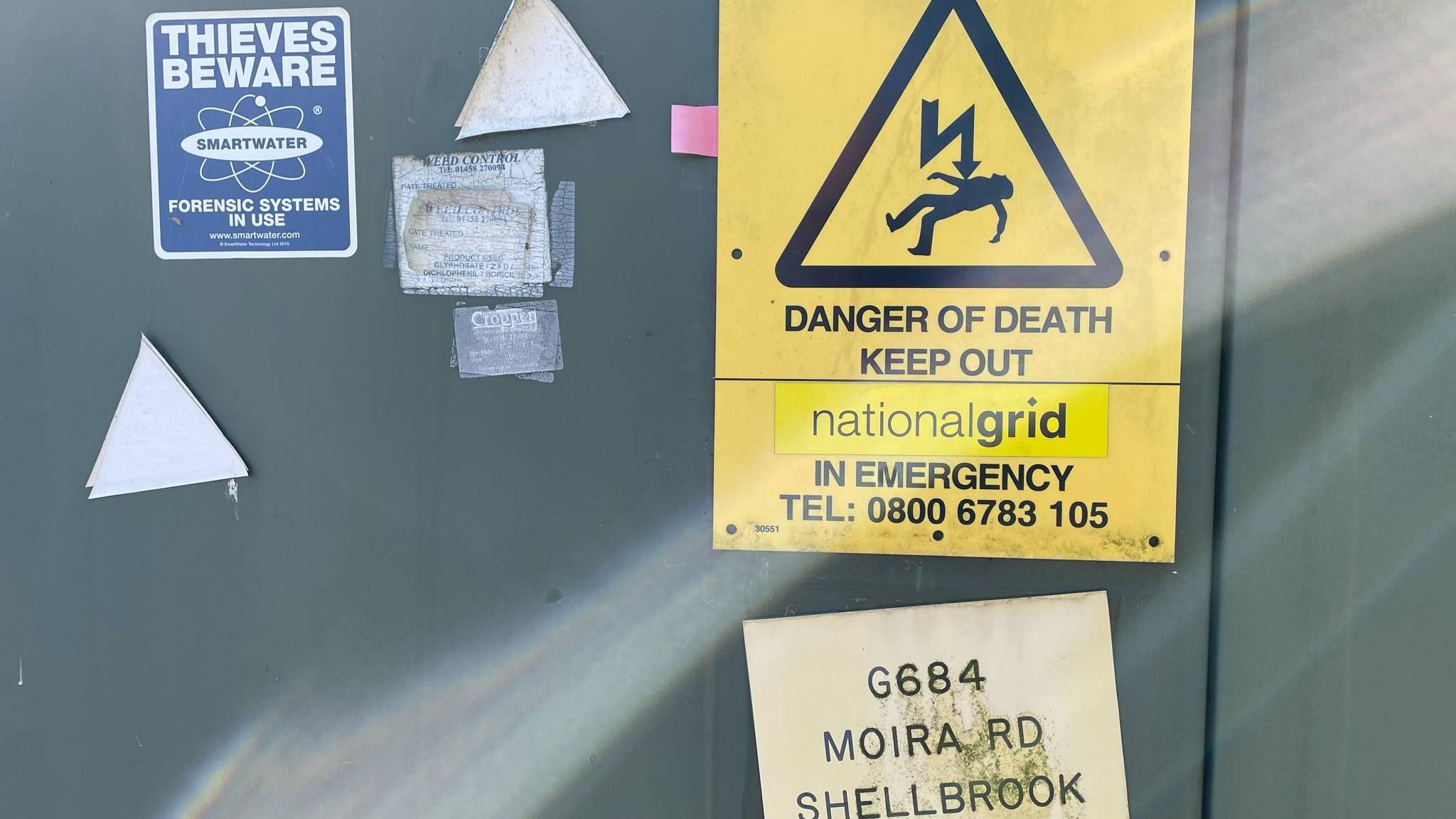Signs on an electrical substation near a solar farm