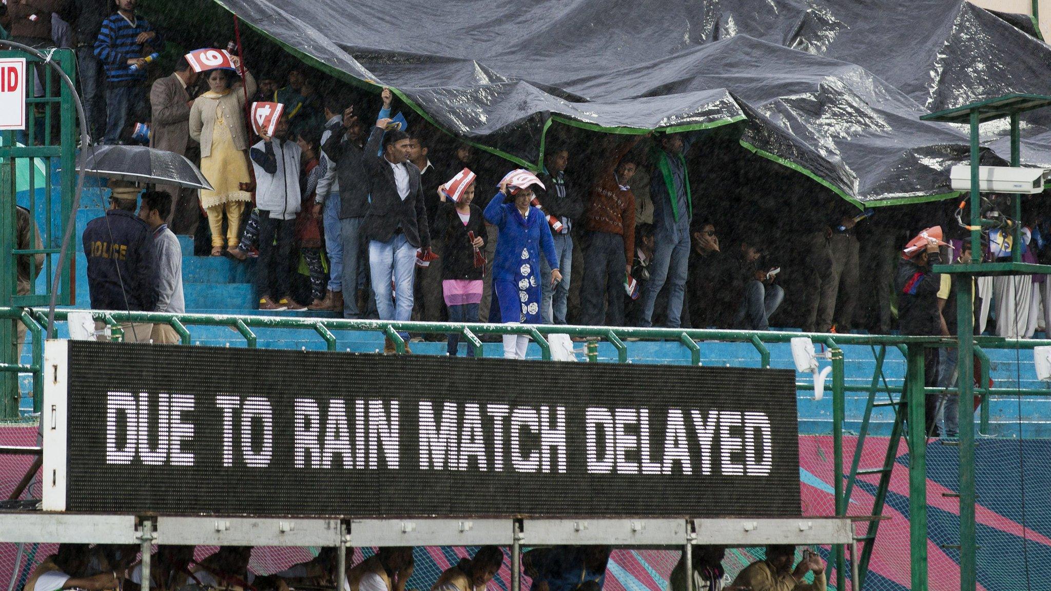 Fans shelter from rain