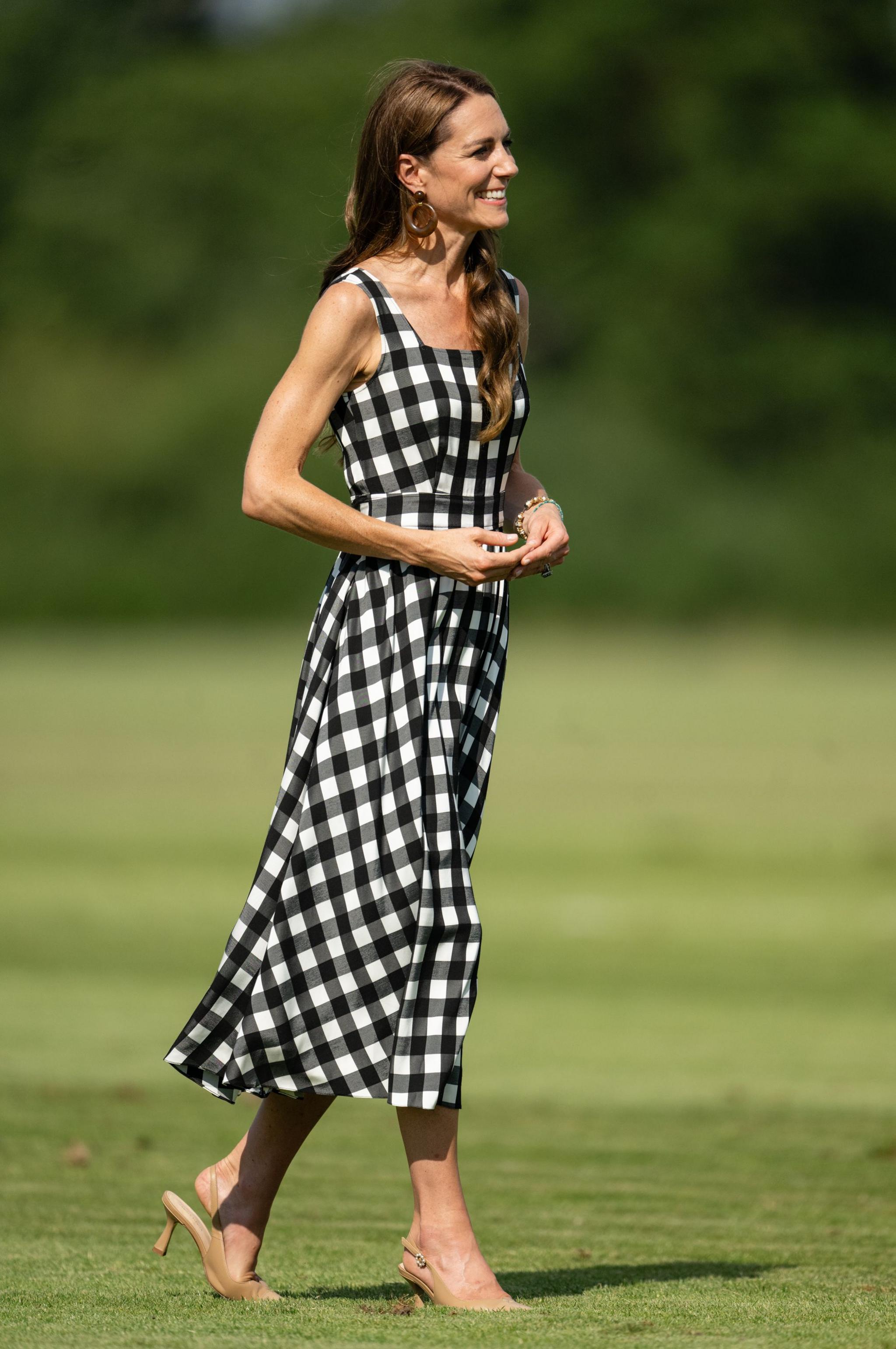  Catherine, Princess of Wales during The Royal Charity Polo Cup 2026 Guards Polo Club on July 10, 2026 wearing a gingham dress with the pitch in the background.
