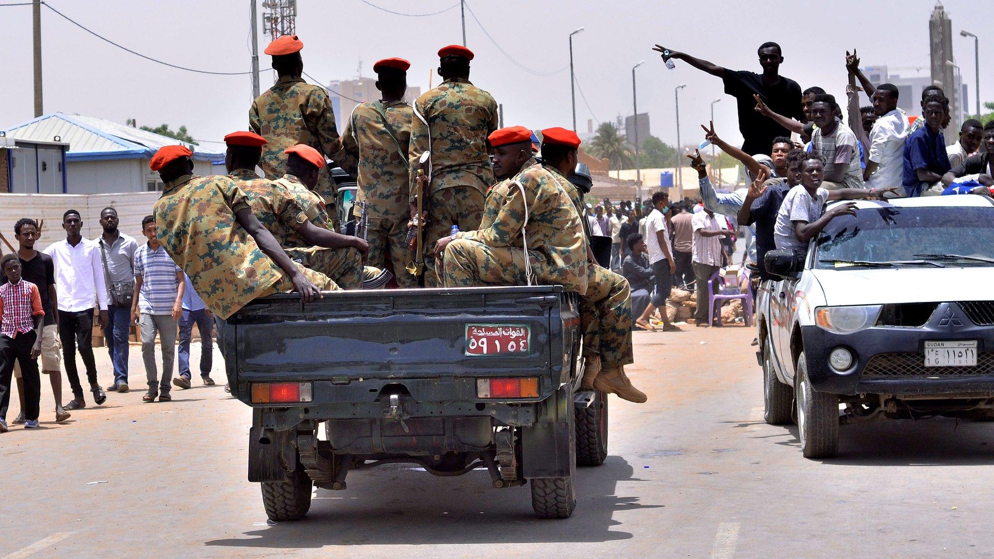 Sudanese demonstrators cheer as they drive towards a military vehicle. Khartoum 11 April 2019