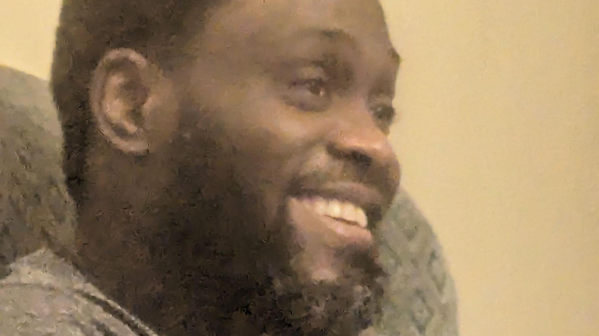 Father Solomon Shamee has a grey T-shirt short haid and a black beard with specs of grey