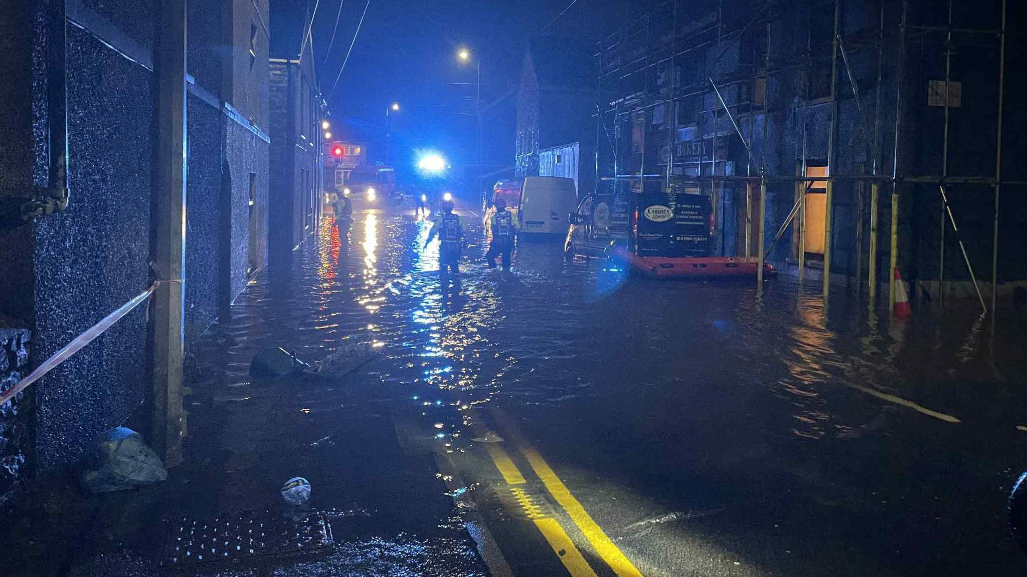 Llun o lifogydd y tu allan i County Stores yn y tywyllwch.