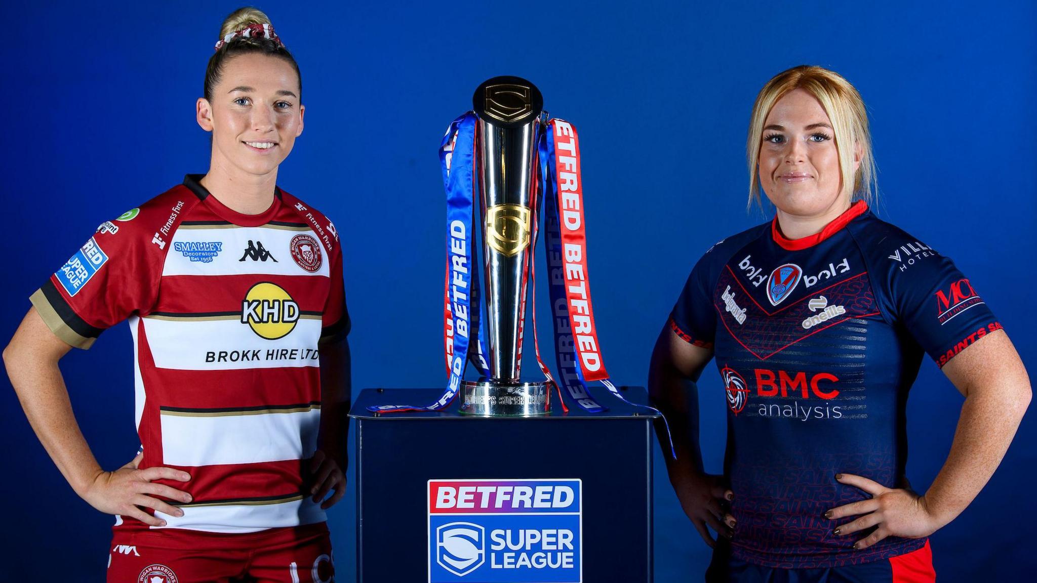 The Betfred Women's Super League trophy with Wigan's Georgia Wilson & St Helens' Caitlin Casey either side