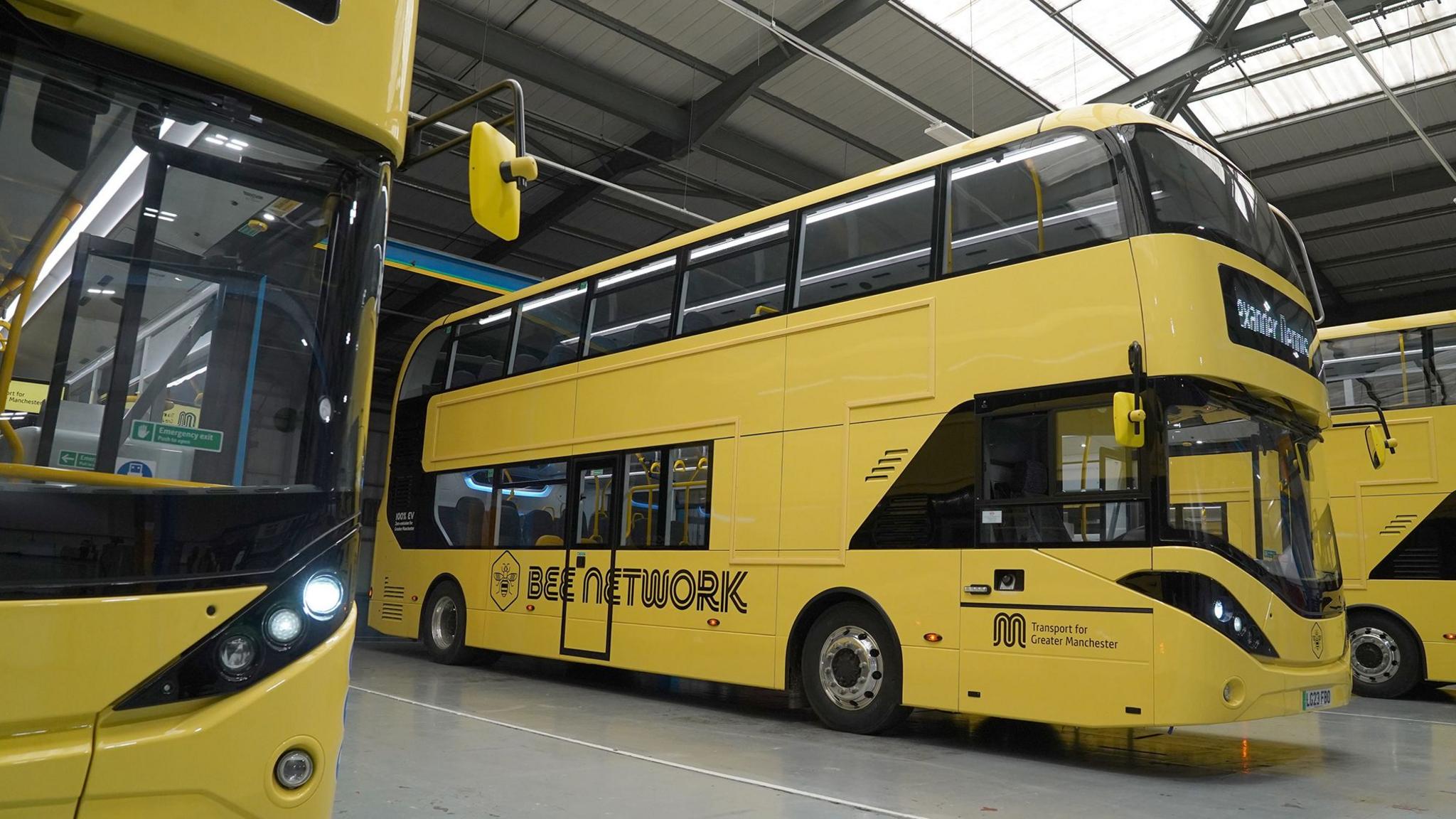 Yellow double decker buses with Bee Network written on the side
