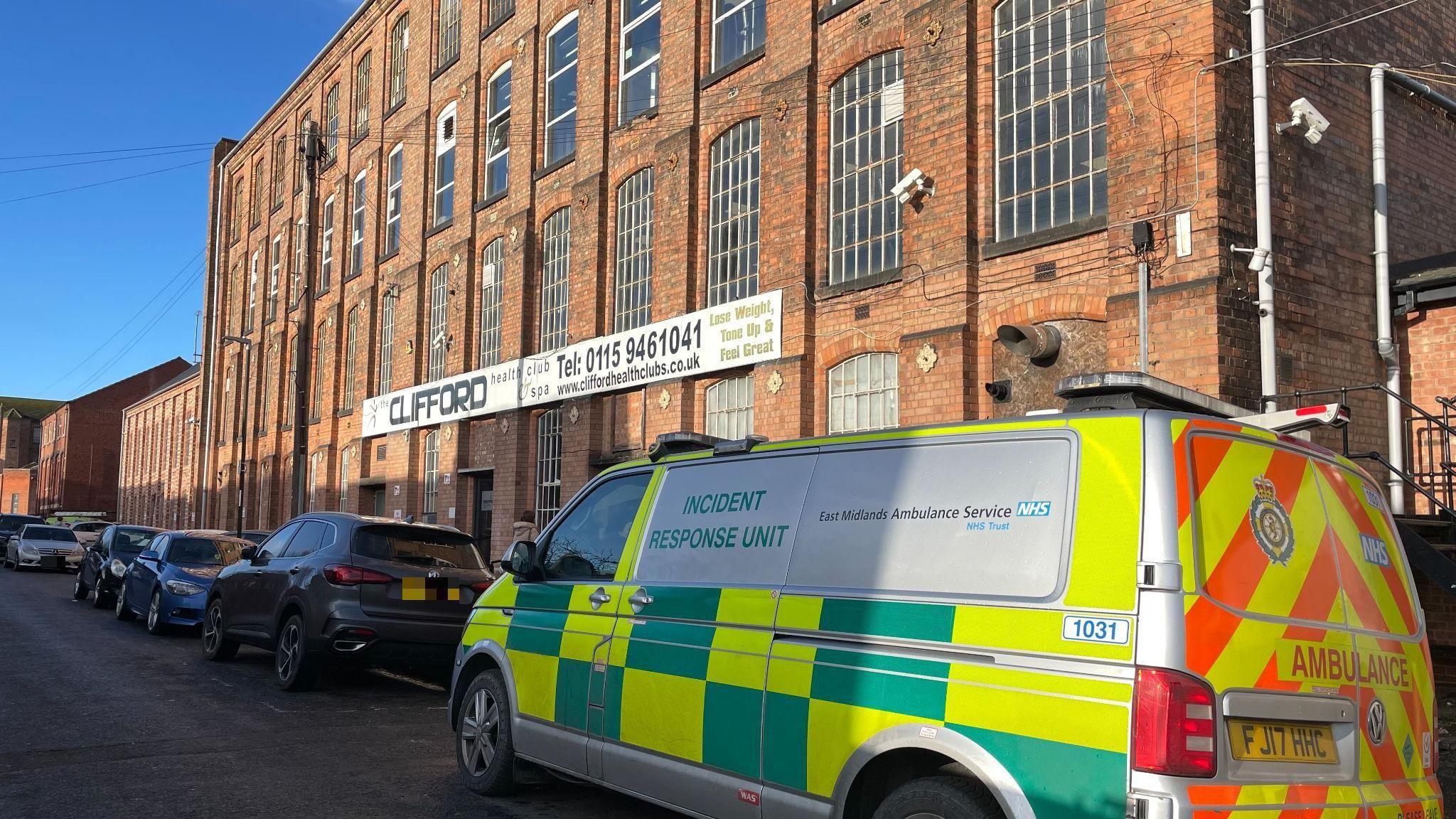 An Incident Response Unit van parked outside Clifford Health Club and Spa, a red brick building.