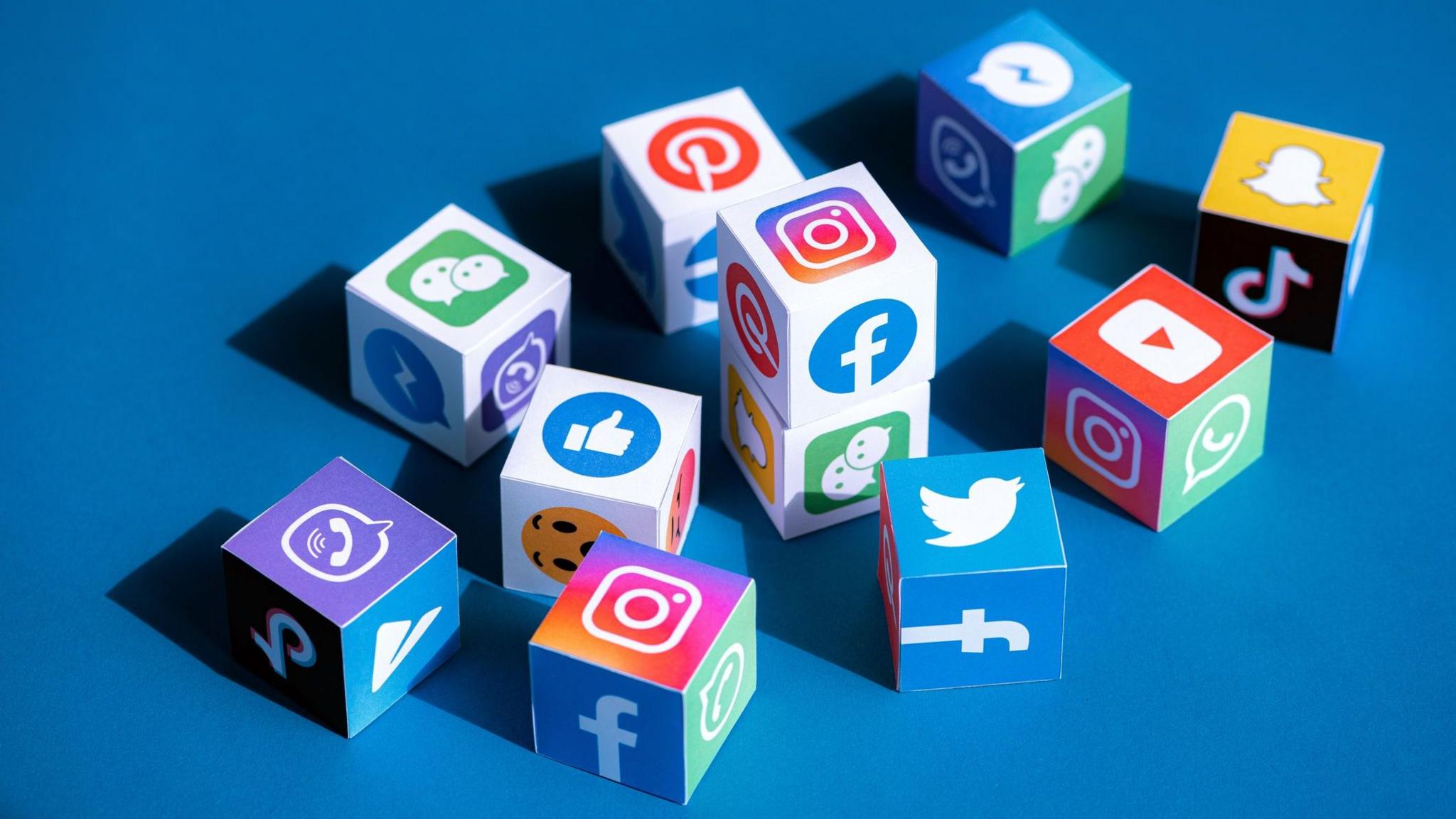 Little dice style cubes with the logo of social media companies on it like TikTok, Instagram, Facebook and Whatsapp