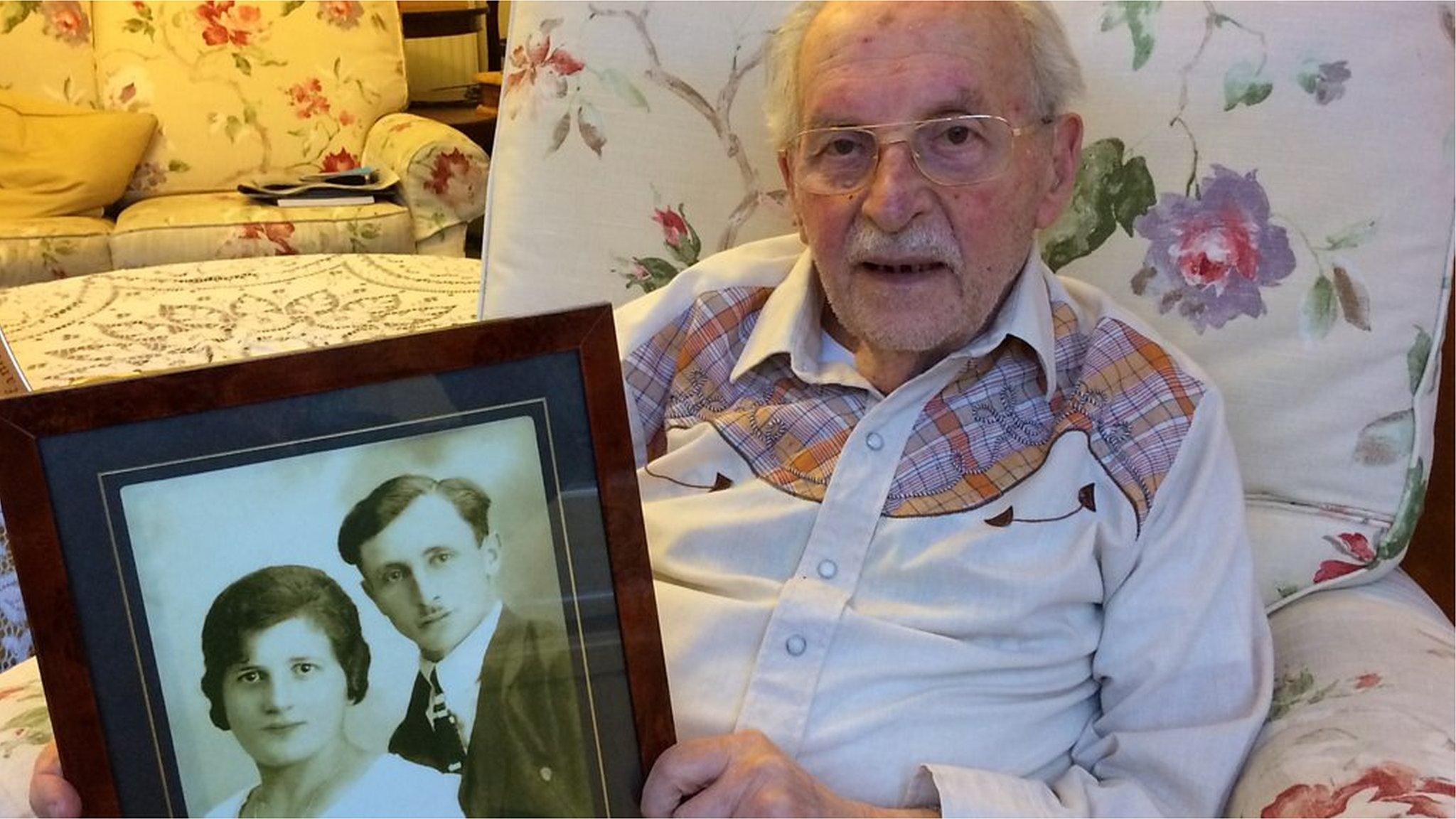 Joe Stirling holding a photo of his parents