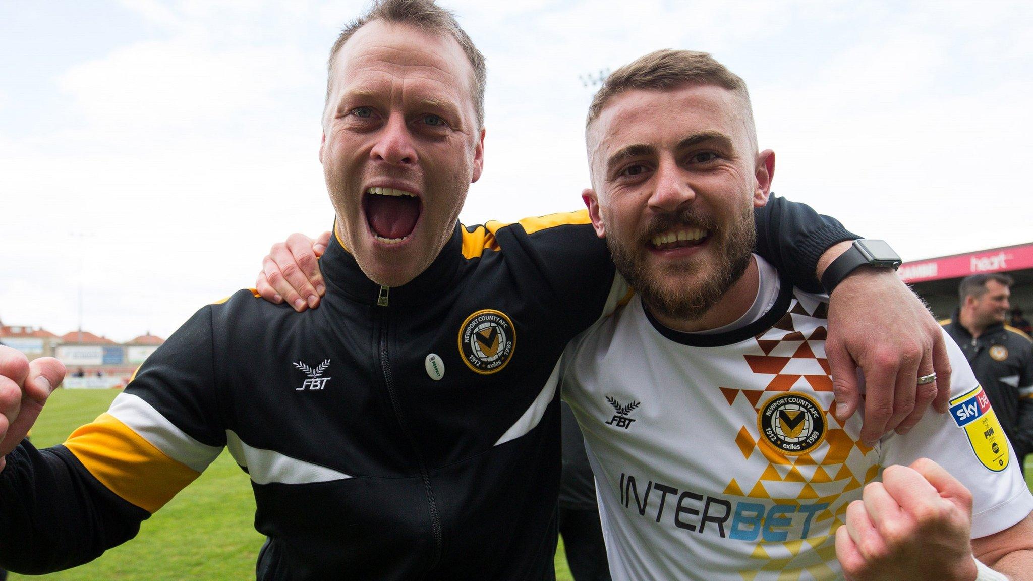 Newport County manager Michael Flynn and player Dan Butler raise clenched fists to the camera after securing a place in the League Two play-offs