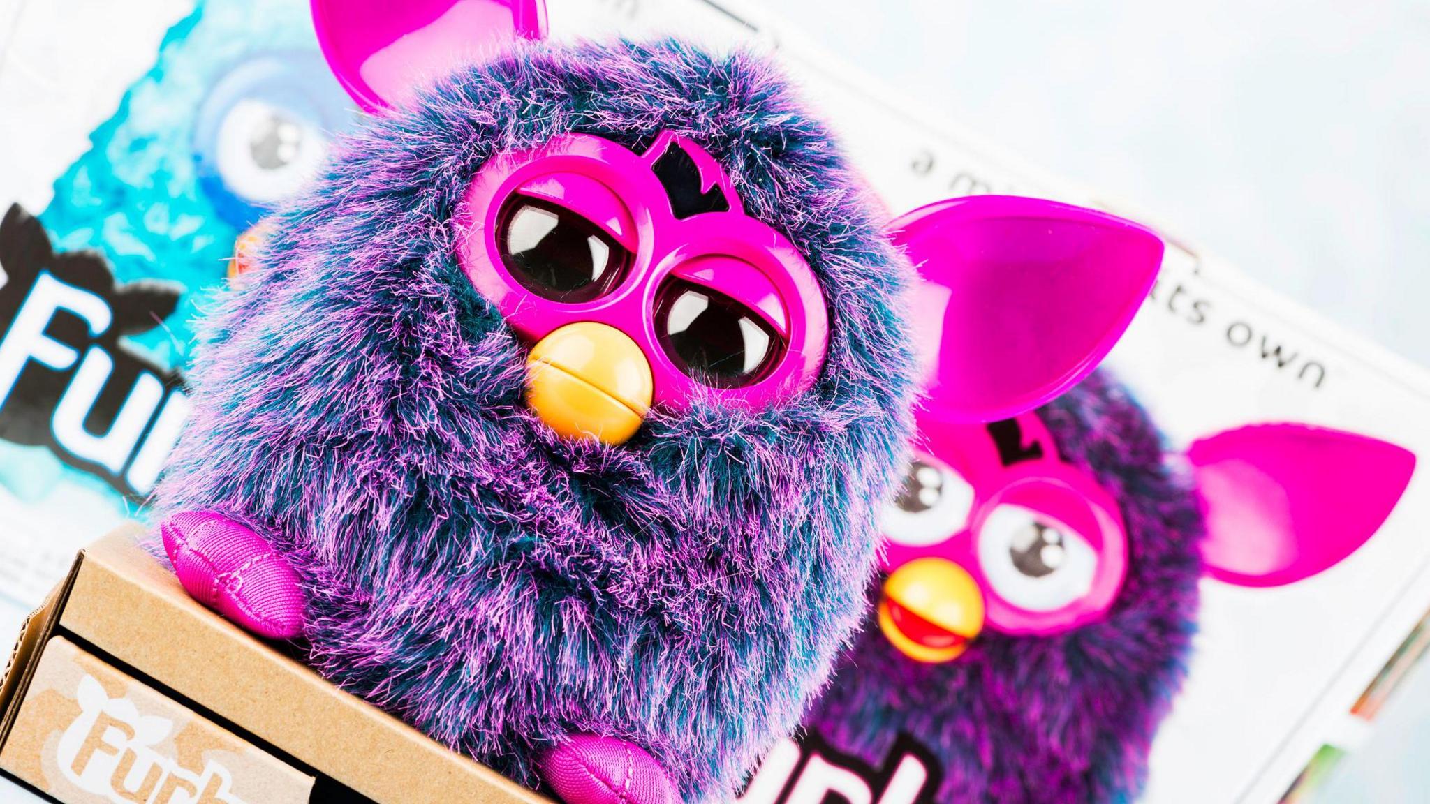 Furby toy in front of packaging.