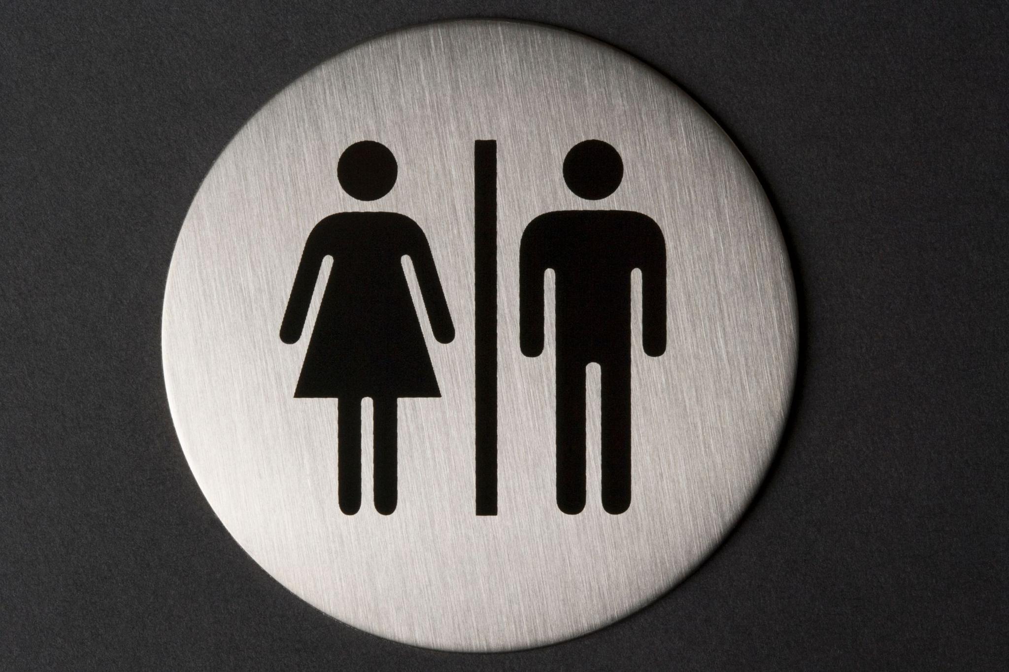 A sign for men's and women's toilets, black outlines on a silver background