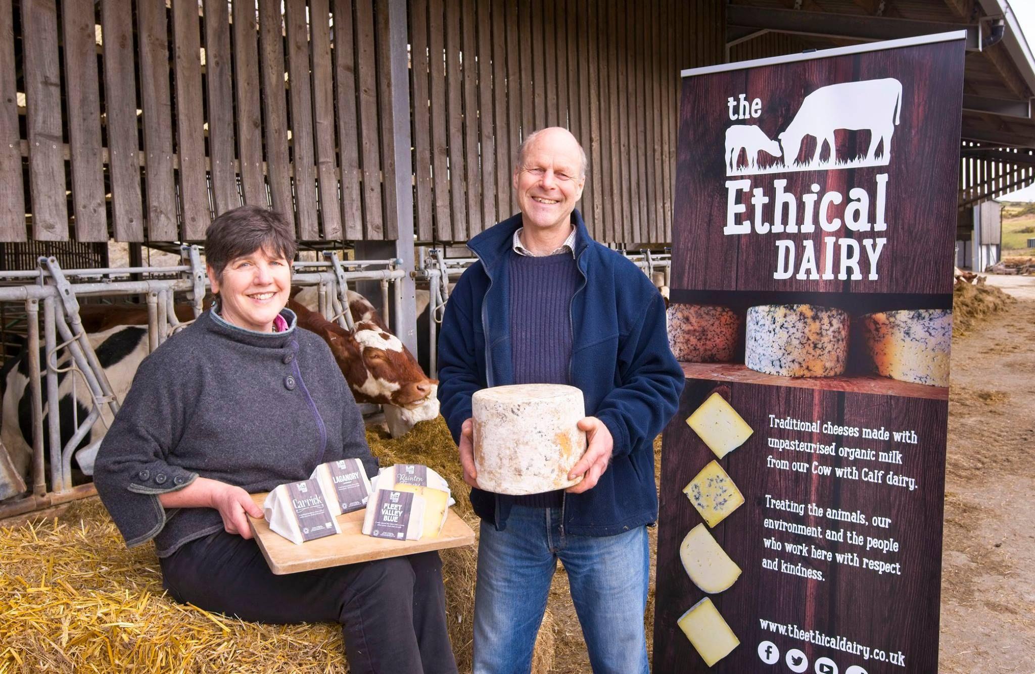 David Finlay and his late wife, Wilma, holding some of their cheese products in front of the cow shed and straw bales