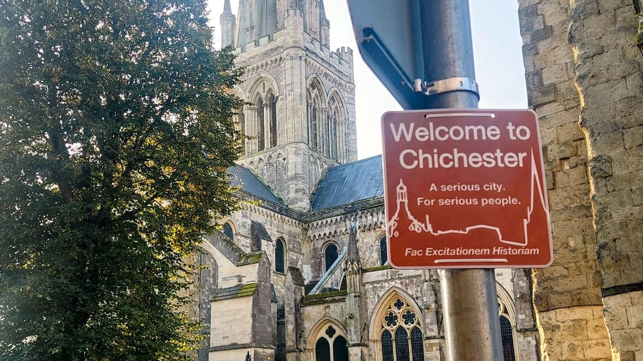 A comic sign reads: Welcome to Chichester. A serious city. For serious people. 