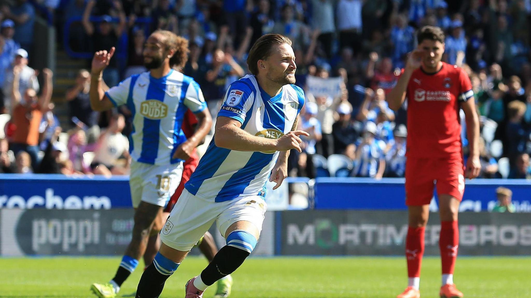 Alfie May runs with his finger pointing in celebration after scoring