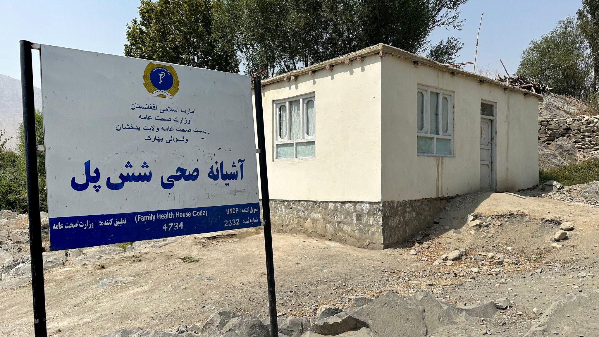 Shesh Pol maternity clinic is pictured with a sign in front of it, it's a small building in a rural looking part of the village in north-eastern Badakhshan province.