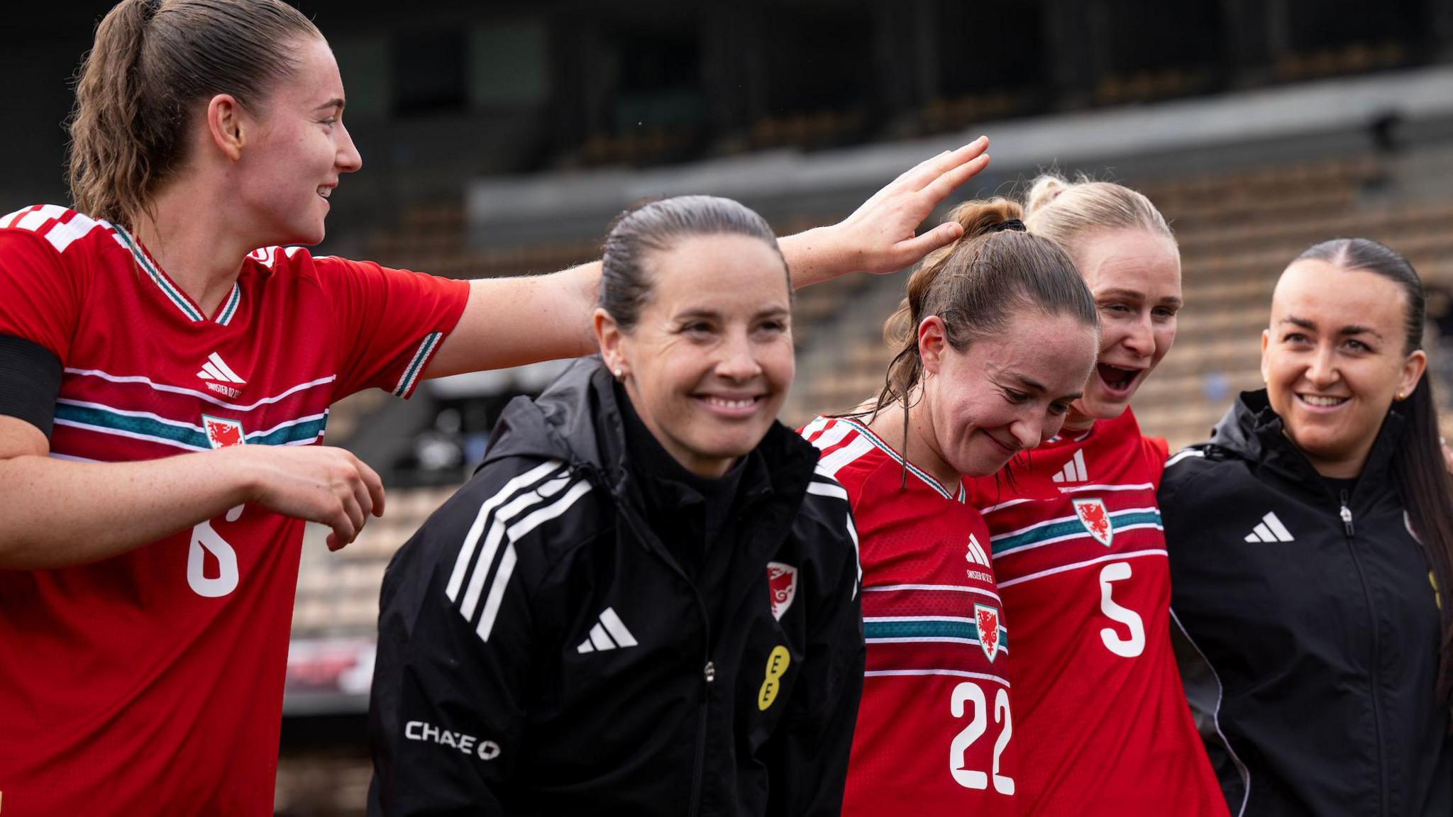 Rhian Wilkinson smiles with some of her players and staff after Wales' win over Switzerland 