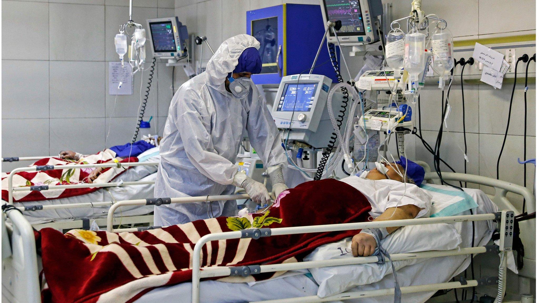 An Iranian medic treats a patient infected with the COVID-19 virus at a hospital in Tehran on March 1, 2020.