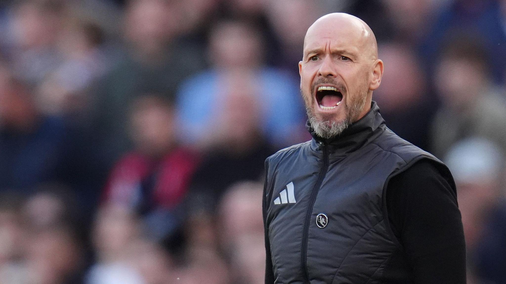 The picture shows Erik ten Hag standing on the sidelines shouting at players on the pitch.