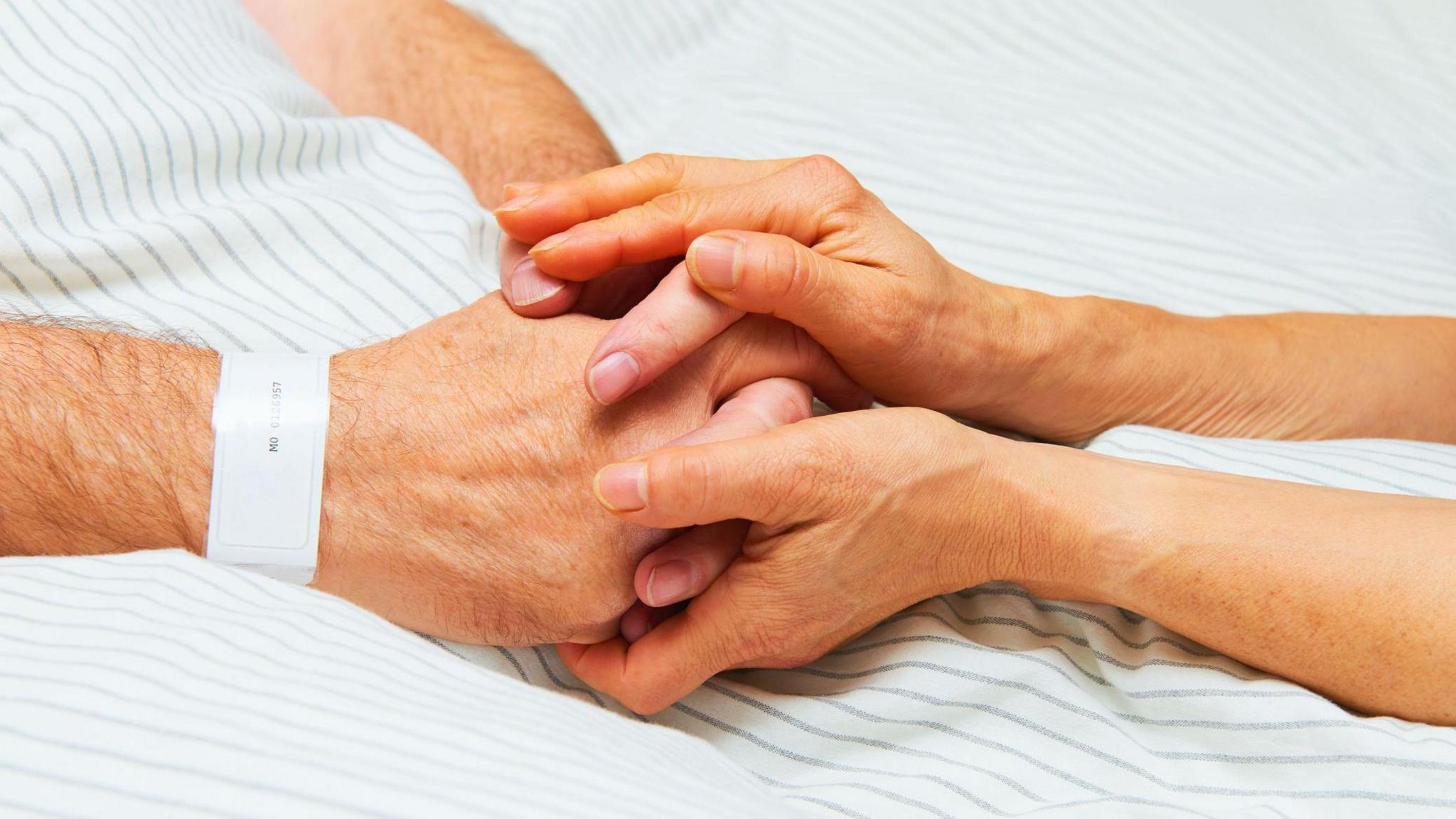 Dau berson yn dal dwylo