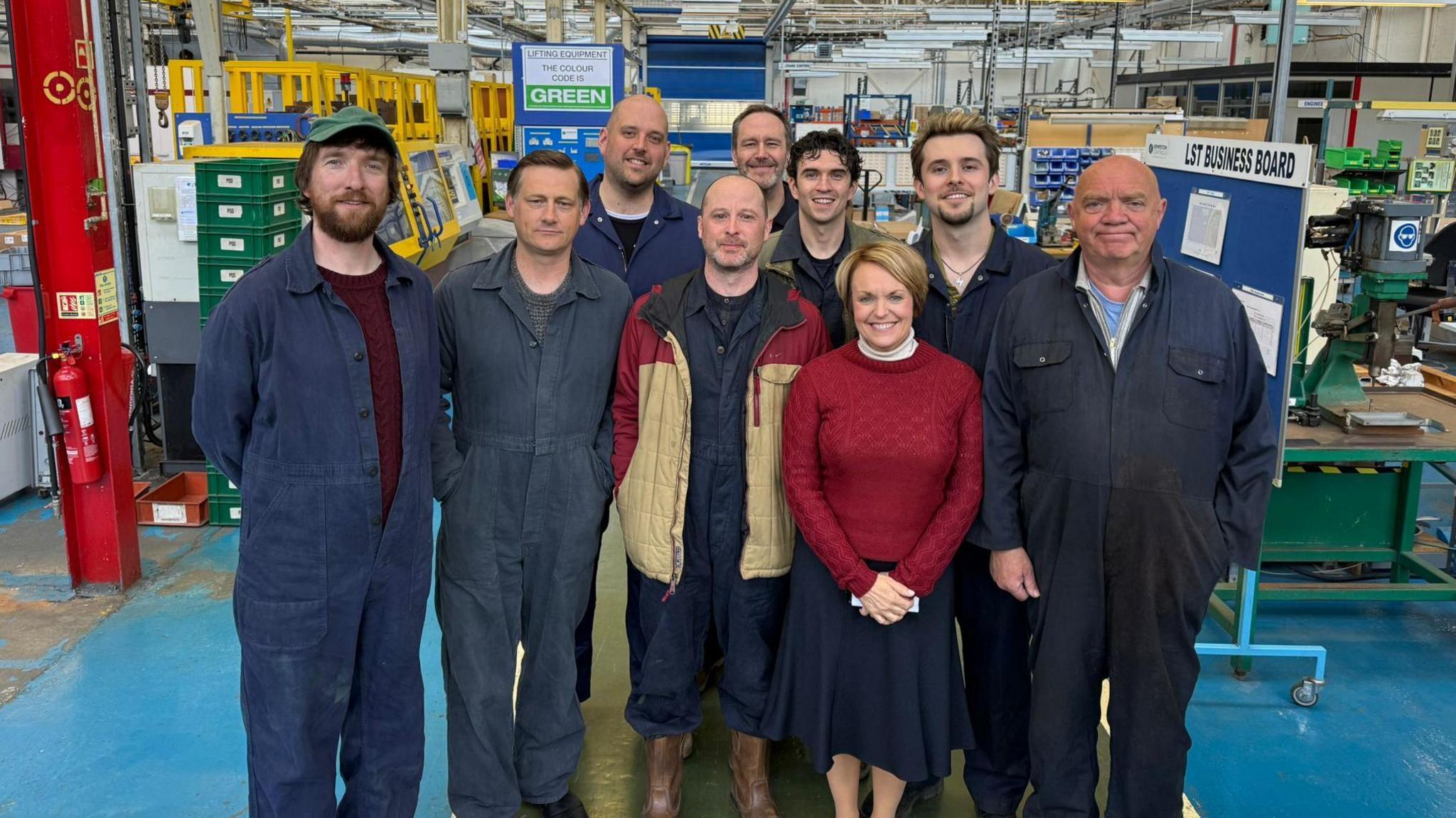 Cast Y Streic Fawr gan gynnwys Gruffudd Glun (chwith) yn ffilmio golygfa ar set y ffatri