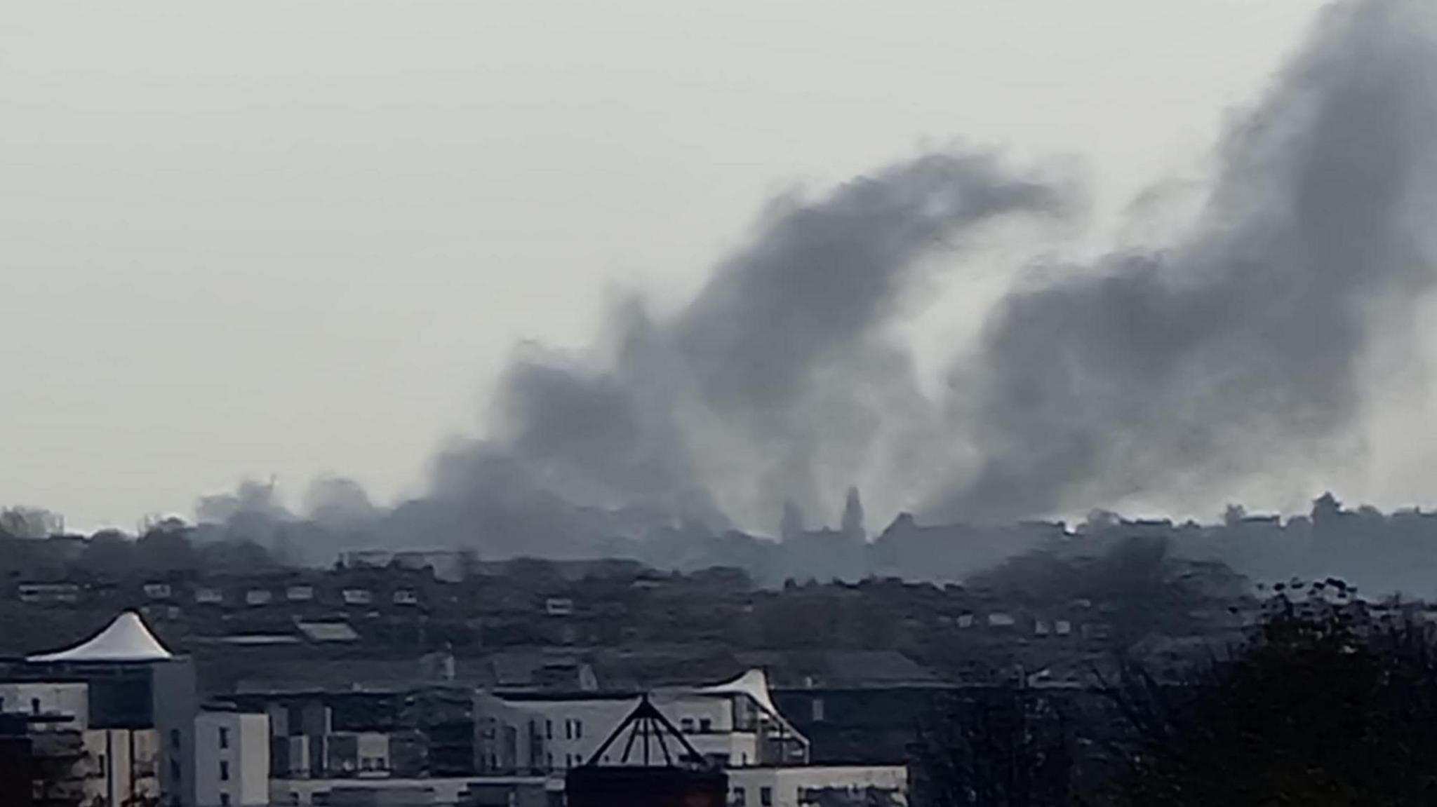 A large plume of black smoke above houses in Leeds.