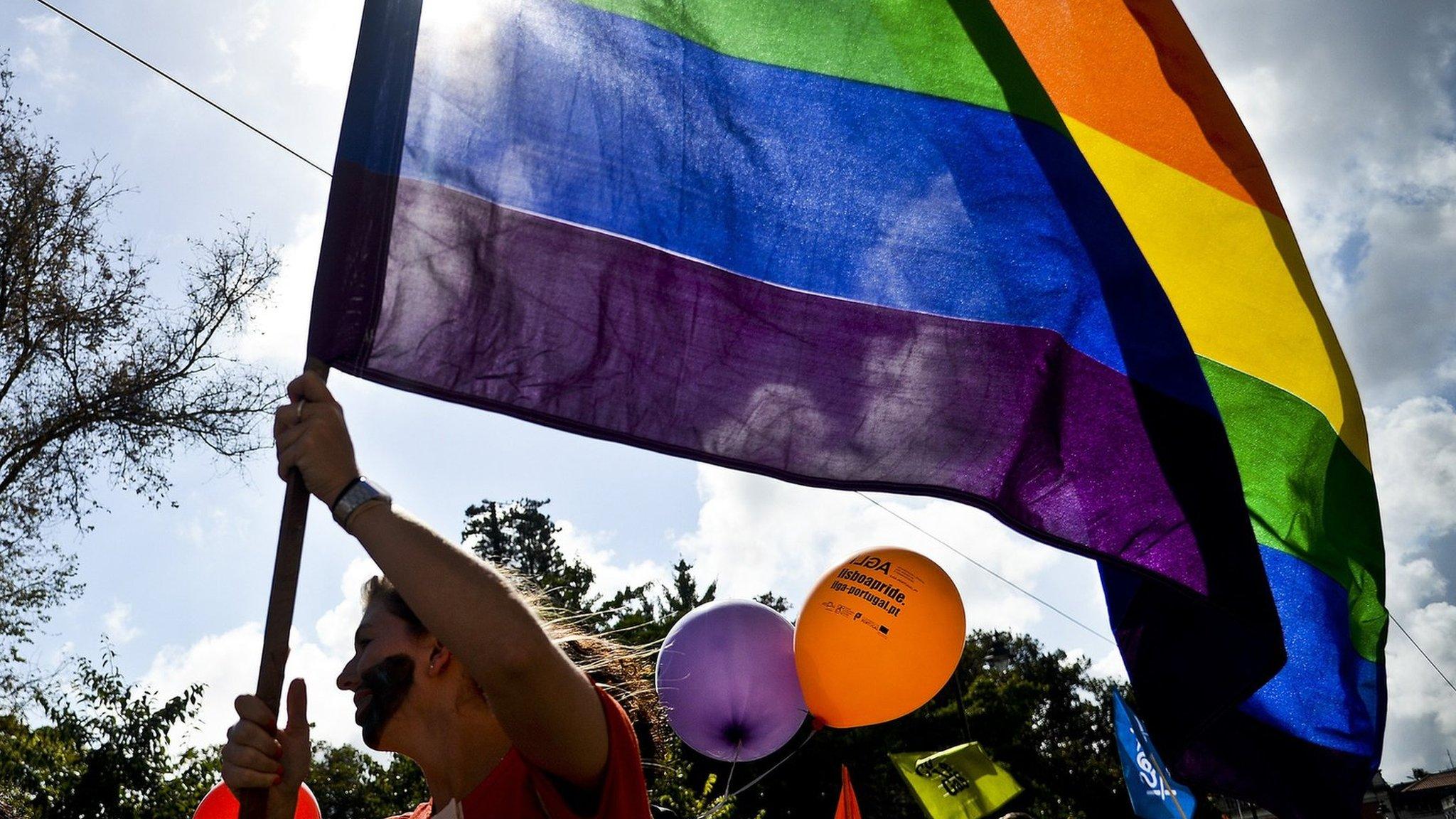 A woman holds a rainbow flag during the Gay Pride Parade in Lisbon on 21 June, 2014