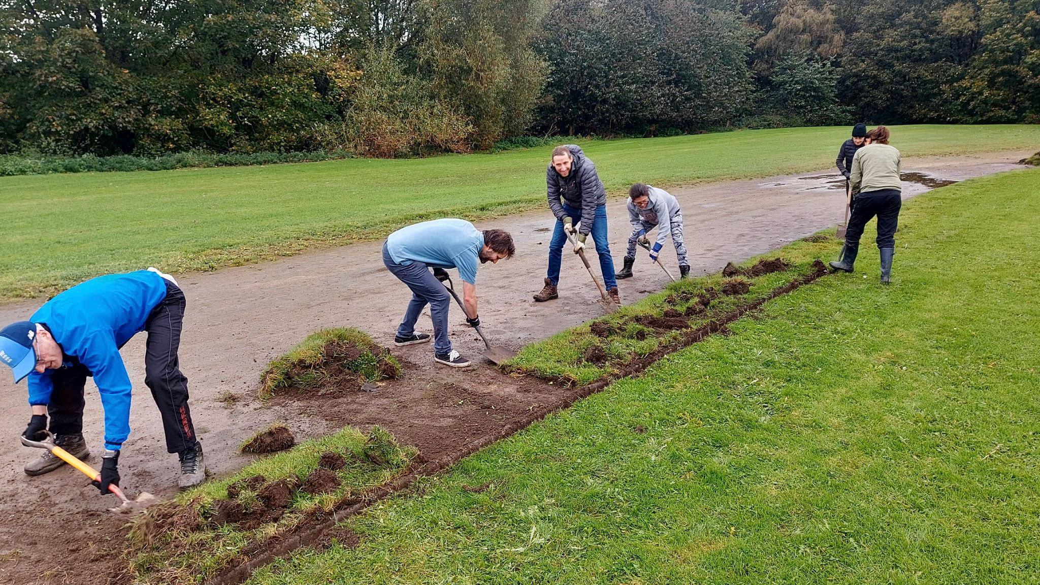 Volunteers digging up the sides of the track