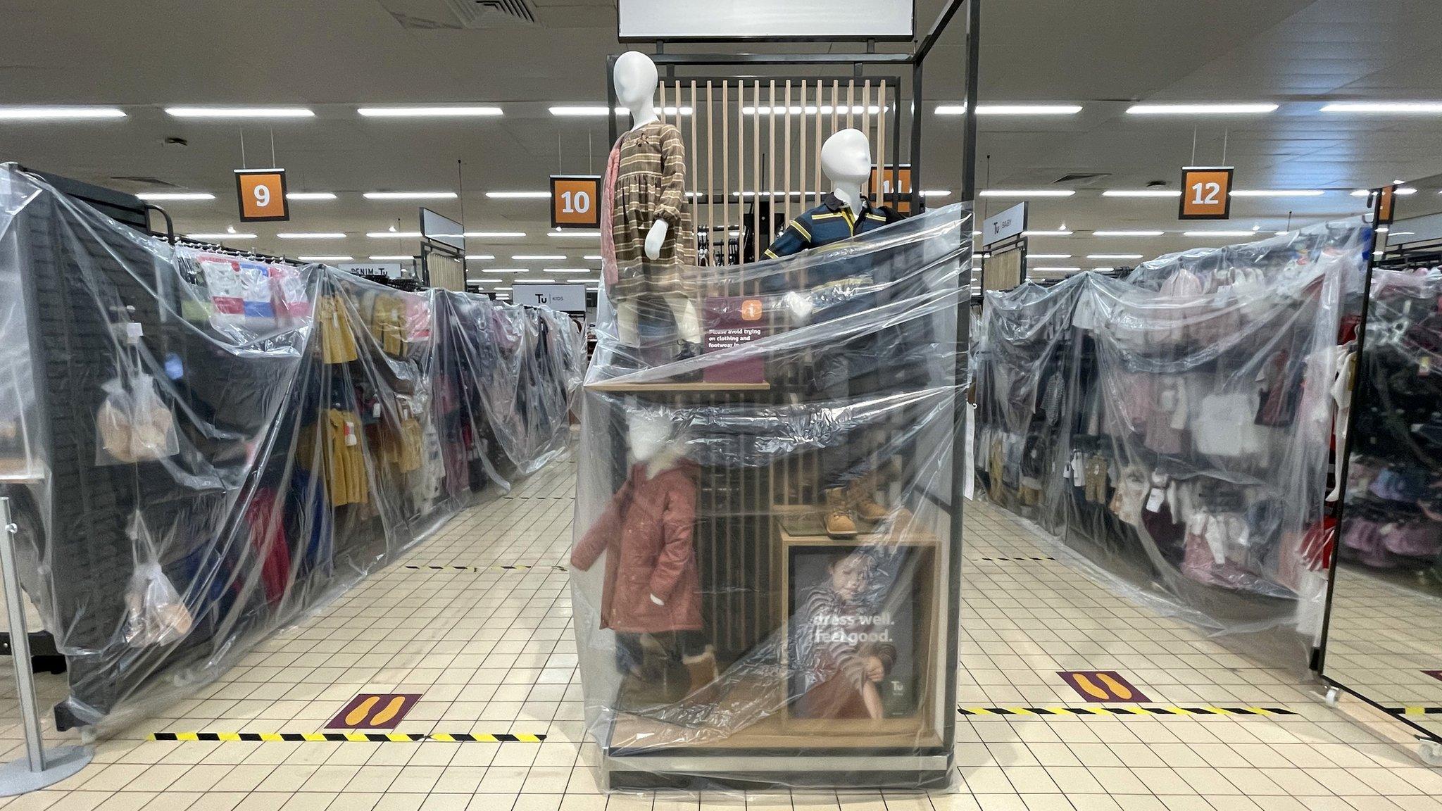 Clothes rails covered in cellophane in Sainsburys in Cardiff