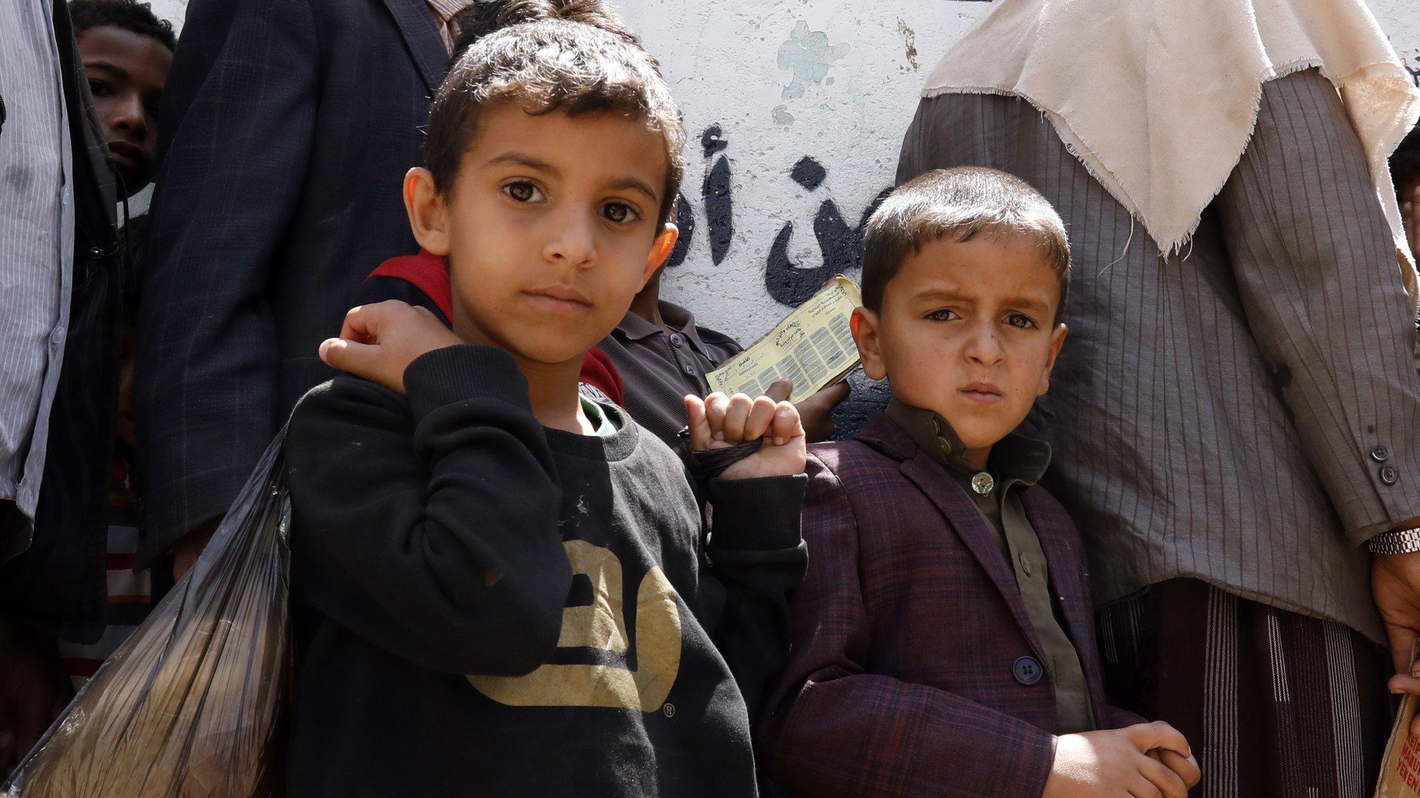 Yemeni children wait to get free food rations from a charity group in Sanaa, April 2020