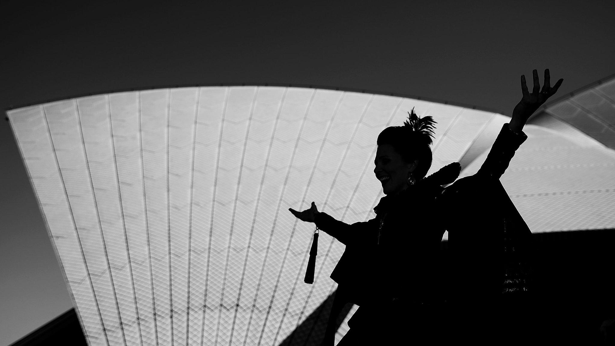 A singer poses outside the Sydney Opera House