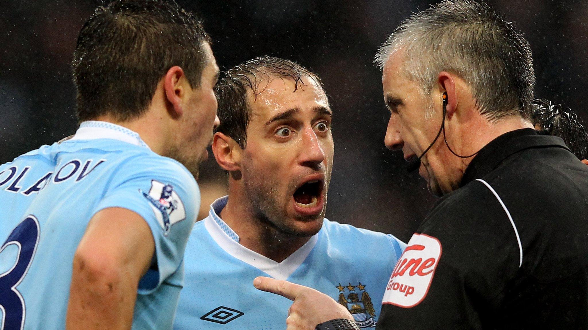 Man City players surround the referee