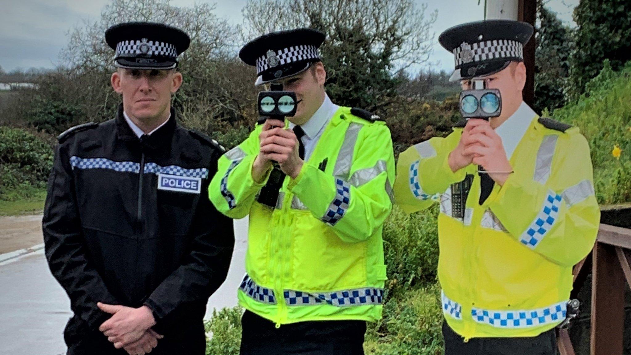 Cut-out police officer with human counterparts