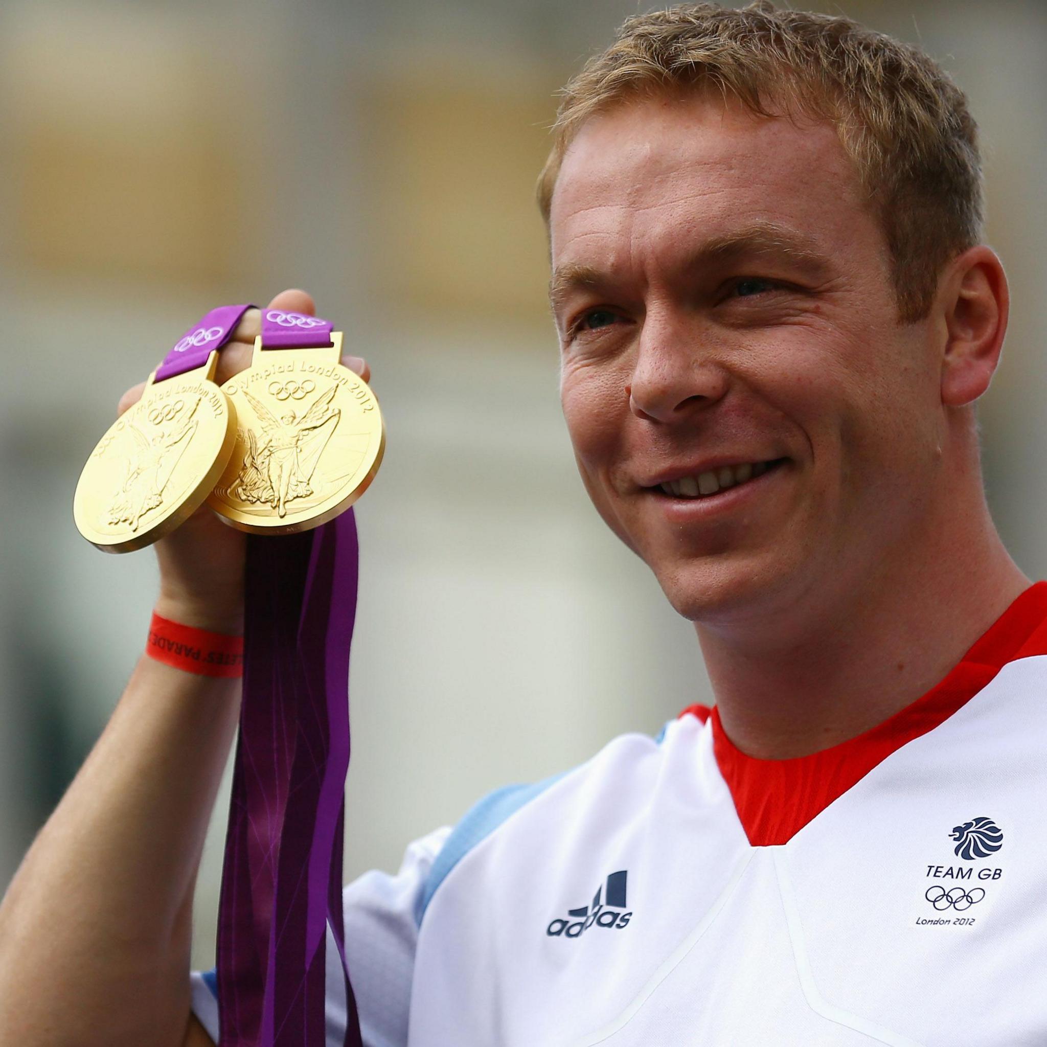Sir Chris Hoy holding up two Olympic gold medals