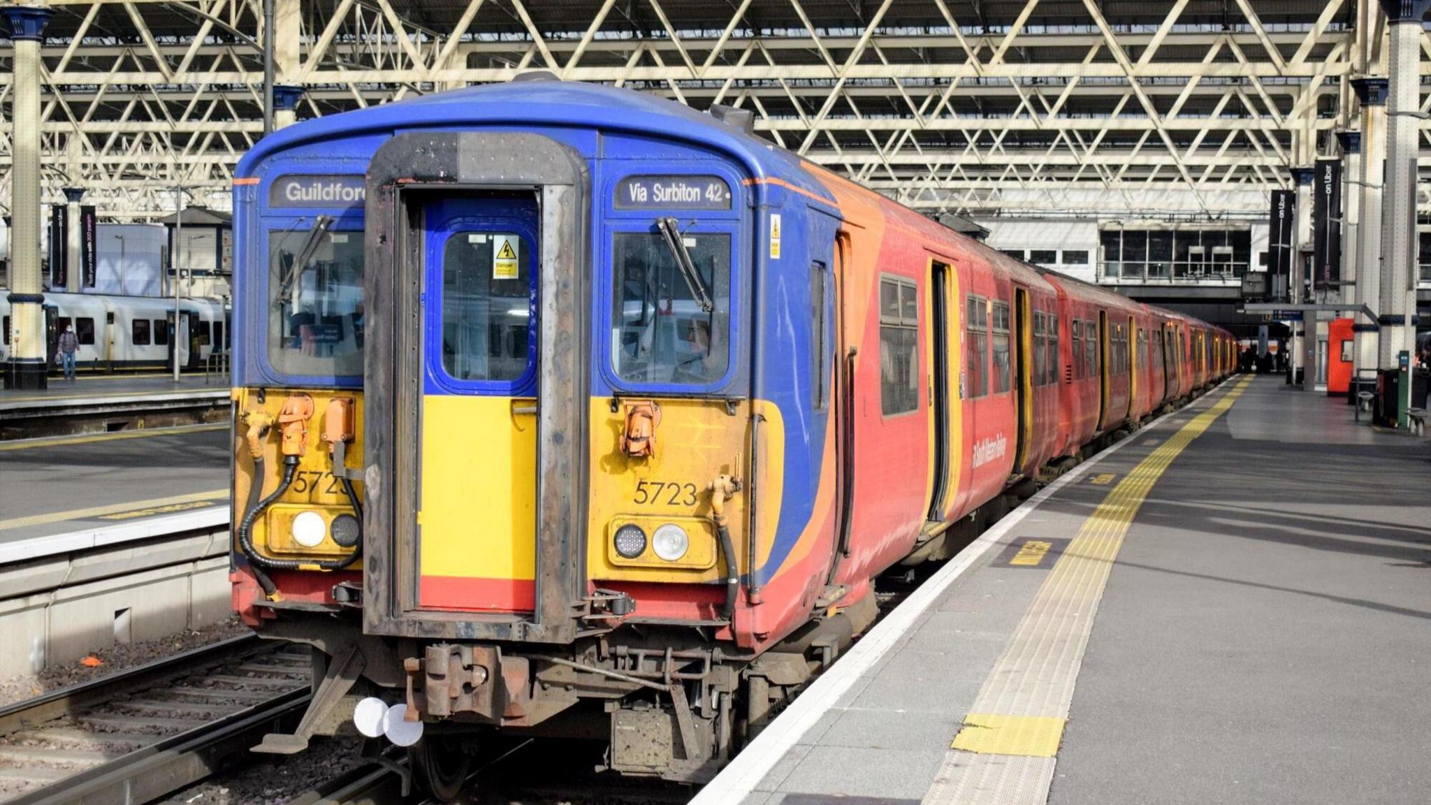 A Class 455 train from the front on the platform of  London Waterloo in South Western Railway livery of blue, yellow and red in 2025 