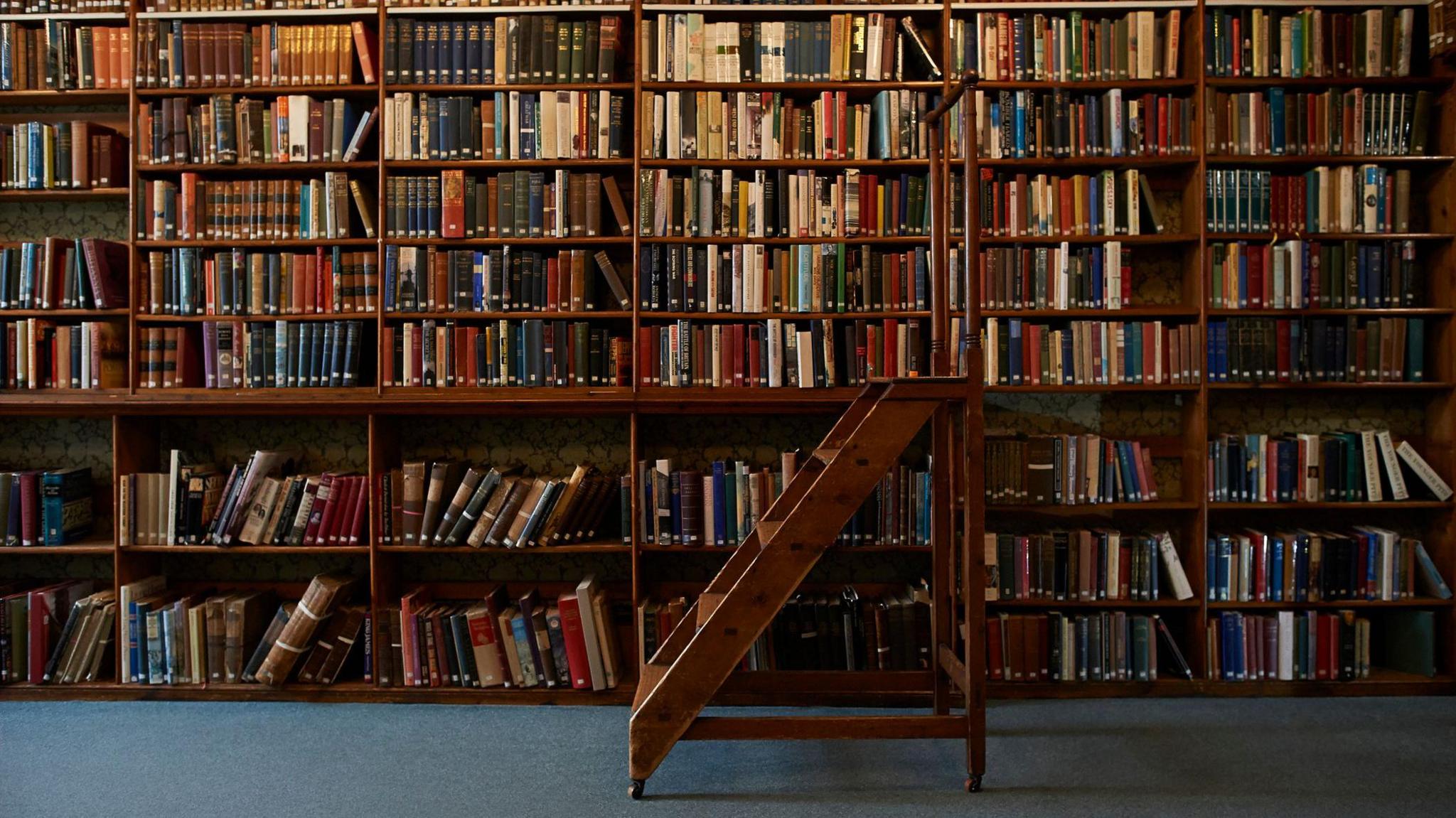 Old fashioned library with a pair of wooden steps.