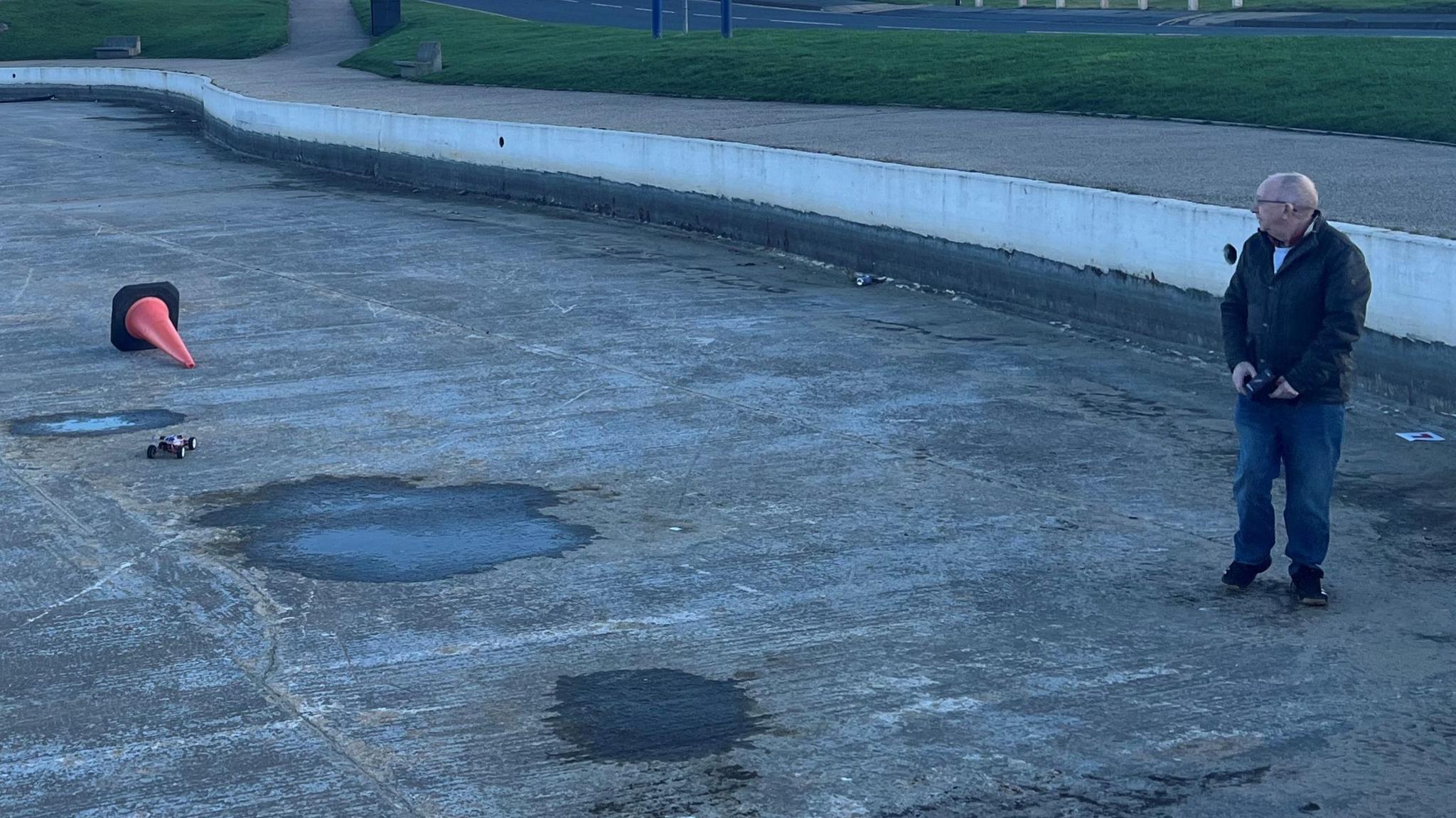 A member of Redcar Boating Club racing a radio-controlled car in the empty lake.
