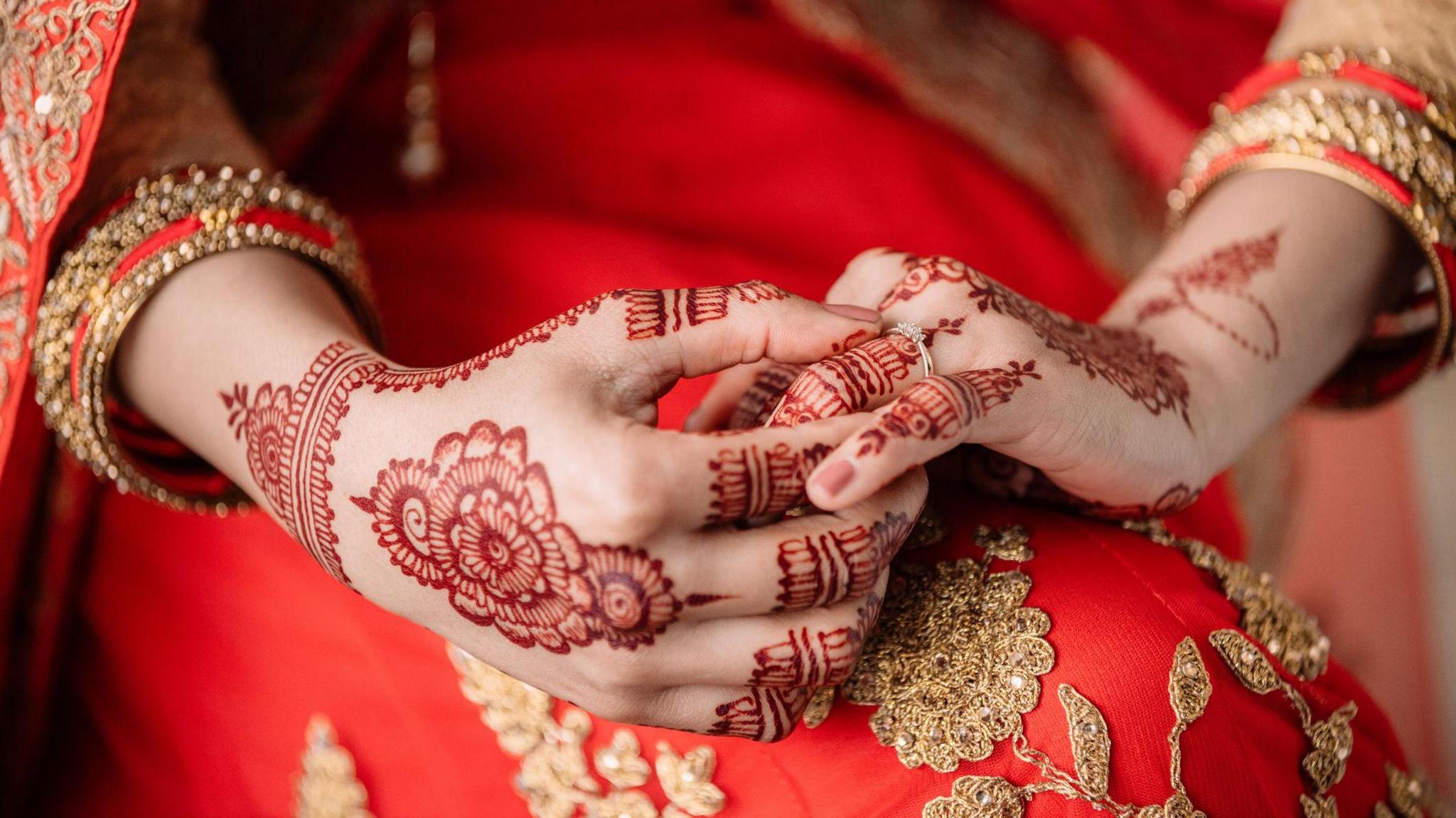 A stock photo of an unrecognizable woman holding a ring in preparation for her wedding