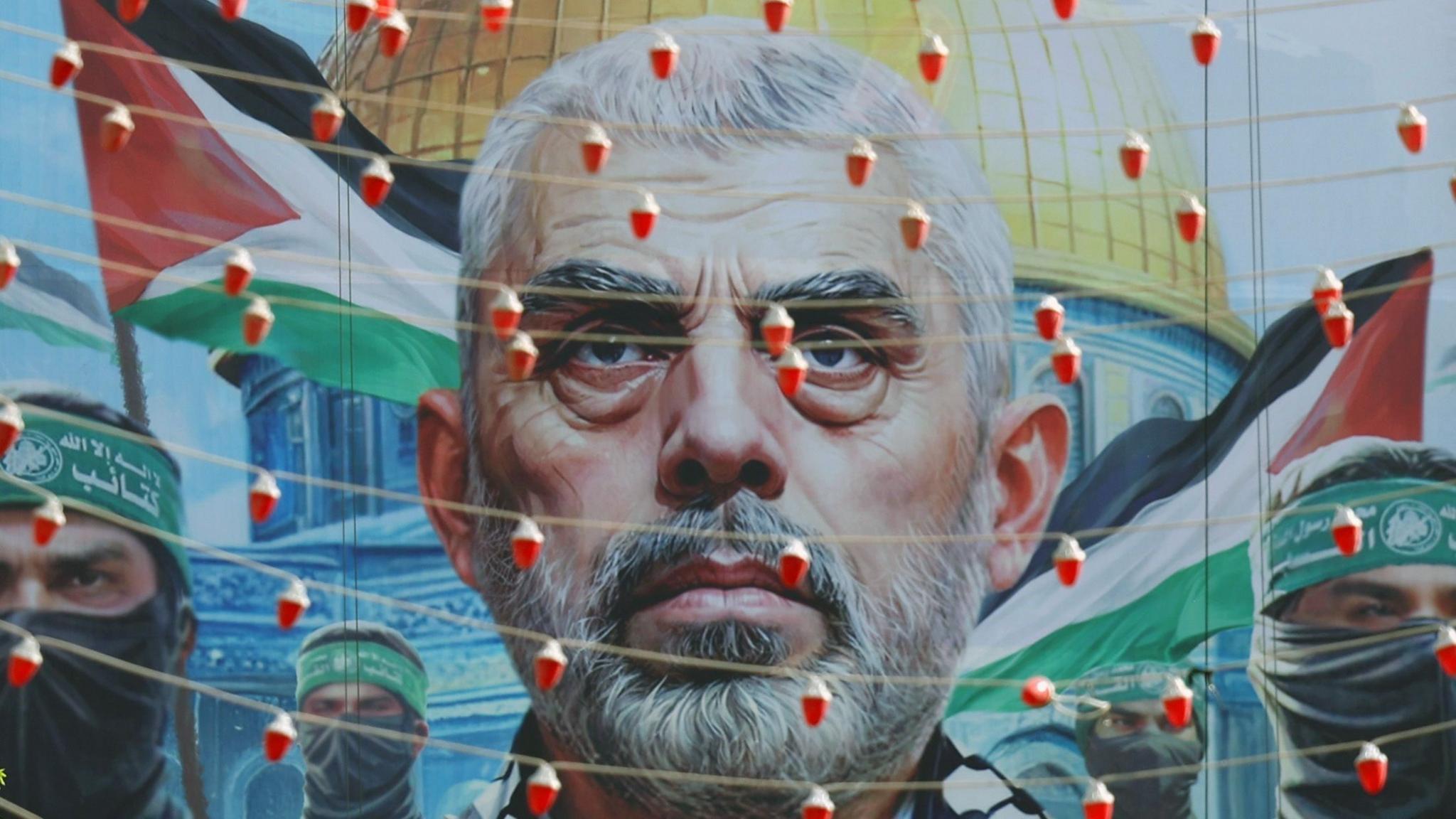 A mural with the face of Yahya Sinwar, the slain former leader of Hamas, beside images of Hamas fighters, with the Palestinian flag and Al-Aqsa mosque in Jerusalem in the background 